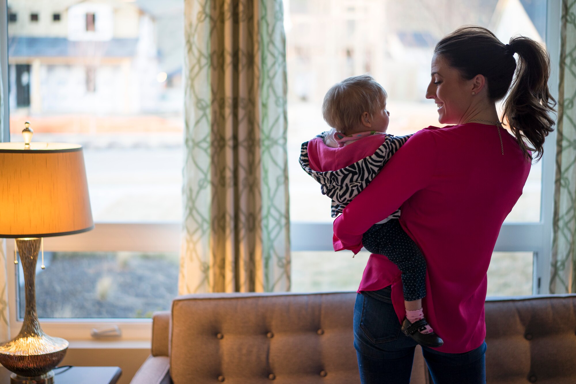 Capt. Lauren Tschampl holds Oleksandra Valley at Tschampl's home in Boise, Idaho. Lauren and her husband, Mark, expressed that they view Oleksandra's adopted parents, Tech. Sgt. Jamie Meadows-Valley and Master Sgt. Ernie Valley, as their role models for what makes good parents. (U.S. Air Force photo/Tech. Sgt. Samuel Morse)