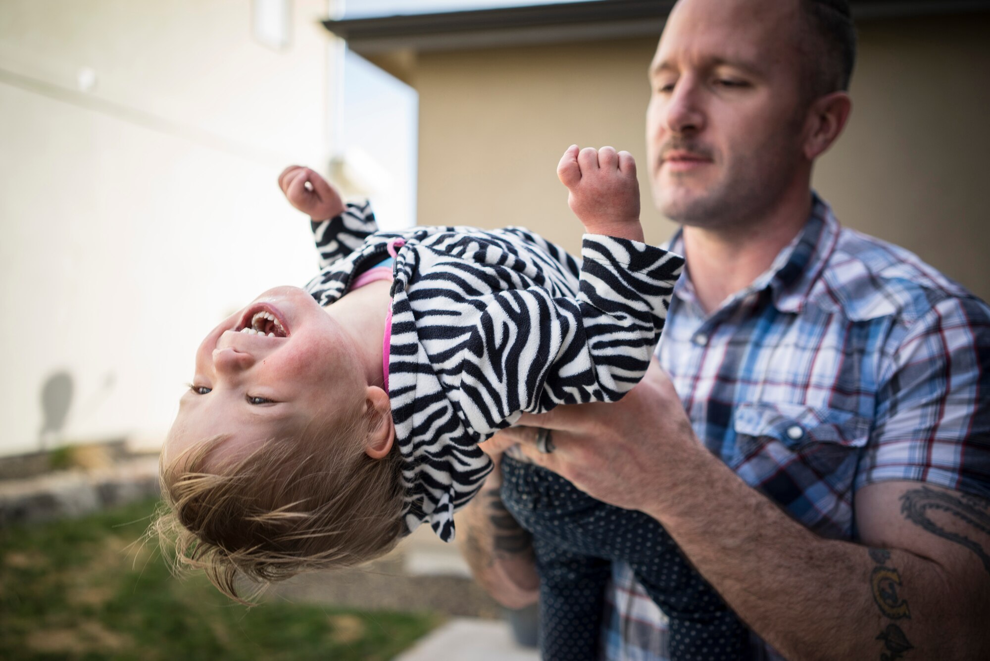 Oleksandra Valley, 2, giggles as her father, Master Sgt. Ernie Valley, plays with her at a friend's house in Boise, Idaho. Oleksandra, affectionately called "Sandie," loves to play with and be held by anyone she meets. (U.S. Air Force photo/Tech. Sgt. Samuel Morse)