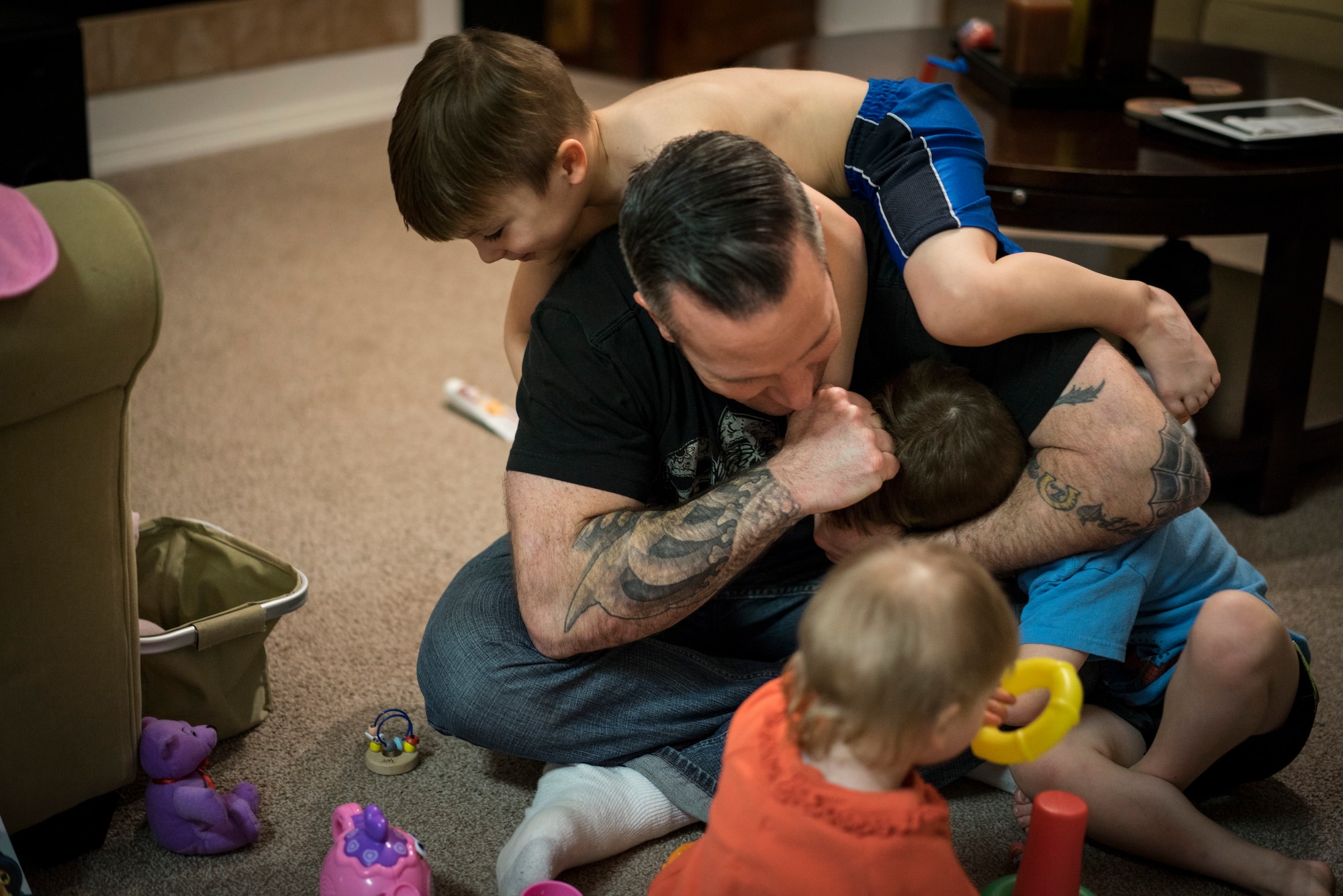 Master Sgt. Ernie Valley plays with his children at their house in Mountain Home, Idaho. His twin boys, Wolfgang and Jaeger, enjoy roughhousing with their father whenever they can. (U.S. Air Force photo/Tech. Sgt. Samuel Morse)