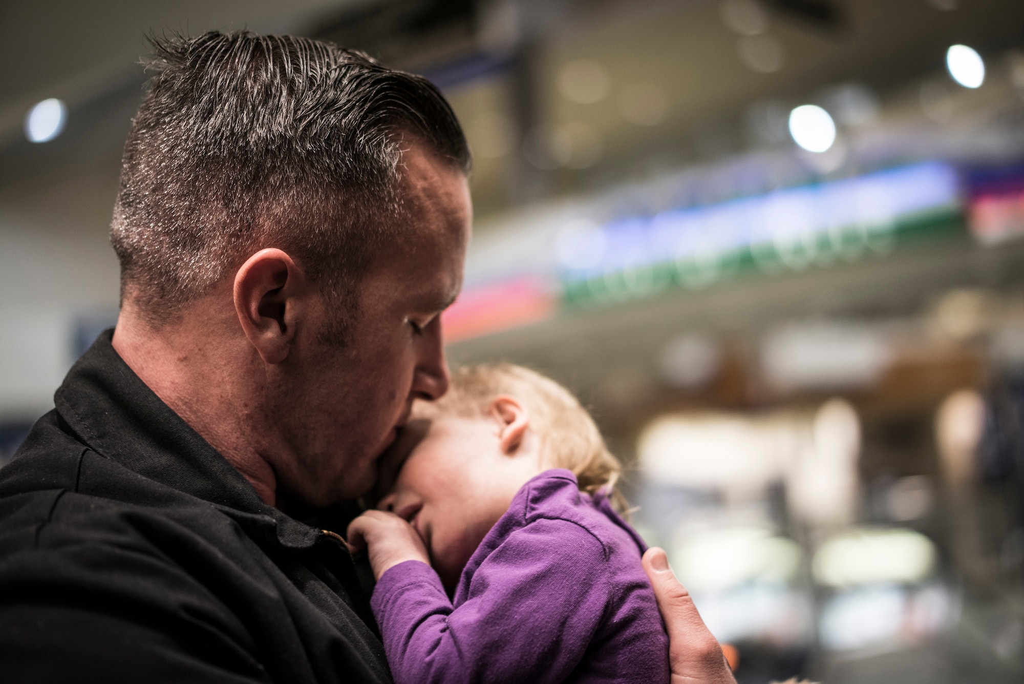 Master Sgt. Ernie Valley cradles his new daughter, Oleksandra, after greeting her at the Boise Airport, Boise, Idaho, on Jan. 23, 2014. Despite not seeing each other for several weeks, Oleksandra immediately appeared to be at home in her new father's arms. (U.S. Air Force photo/Tech. Sgt. Samuel Morse)