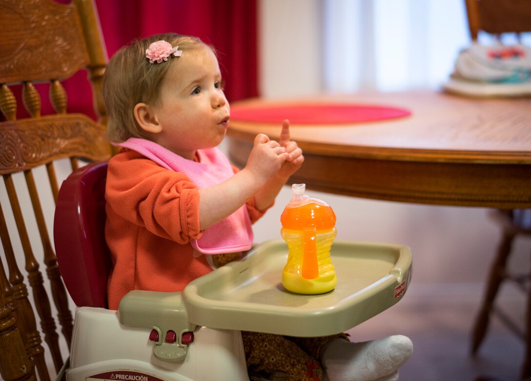 Oleksandra Valley, 2, makes the sign language gesture for "more," indicating she wants more food, at the Valley residence in Mountain Home, Idaho. In a week, she went from being spoon-fed at a Ukrainian orphanage to communicating her desire for more food through sign language and beginning to feed herself. (U.S. Air Force photo/Tech. Sgt. Samuel Morse)