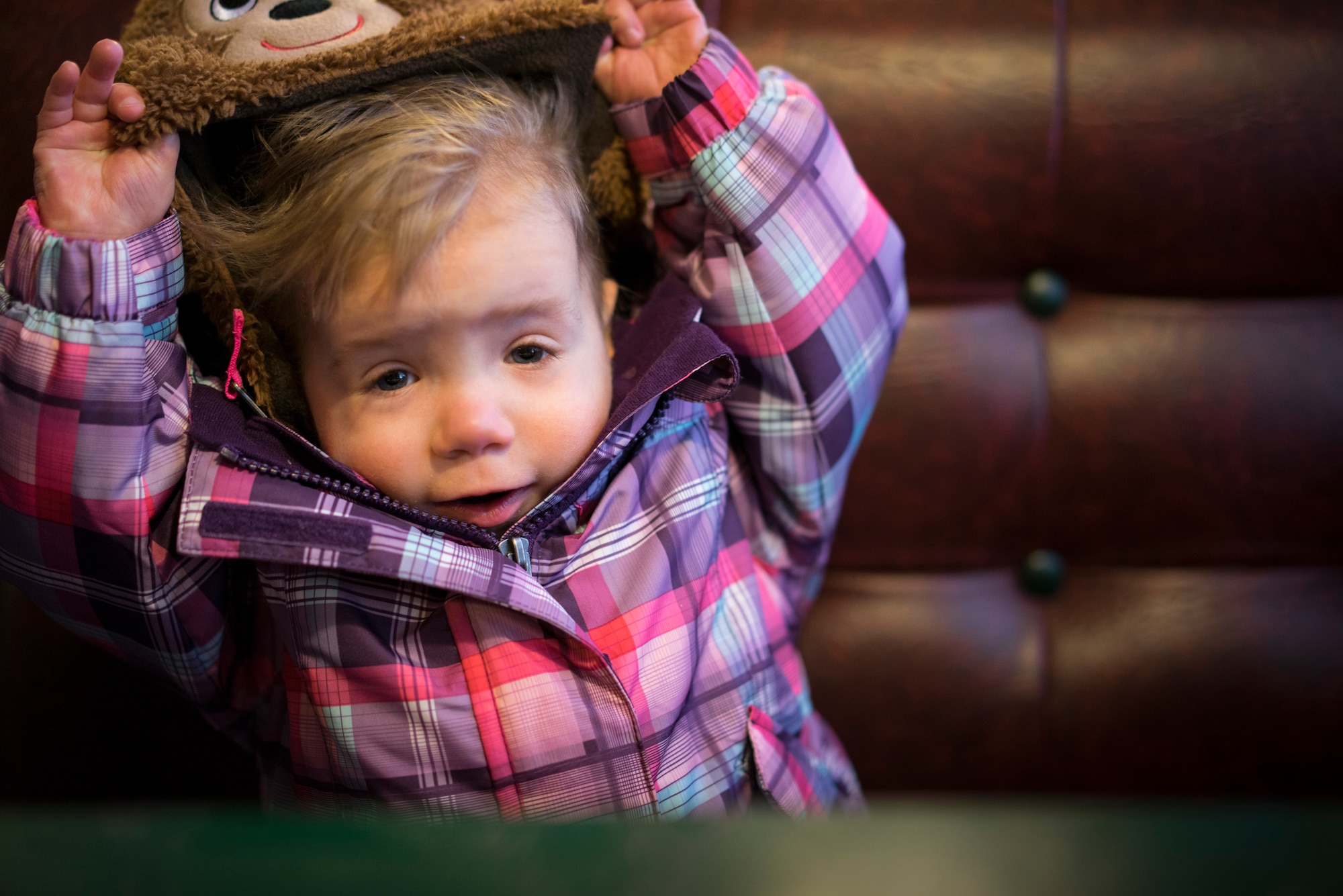 Oleksandra Valley, 2, lifts up her hat after it was playfully pulled down over her face at a restaurant in Mountain Home, Idaho. Affectionately called "Sandie," Oleksandra's smile spreads to almost anyone around her. (U.S. Air Force photo/Tech. Sgt. Samuel Morse)