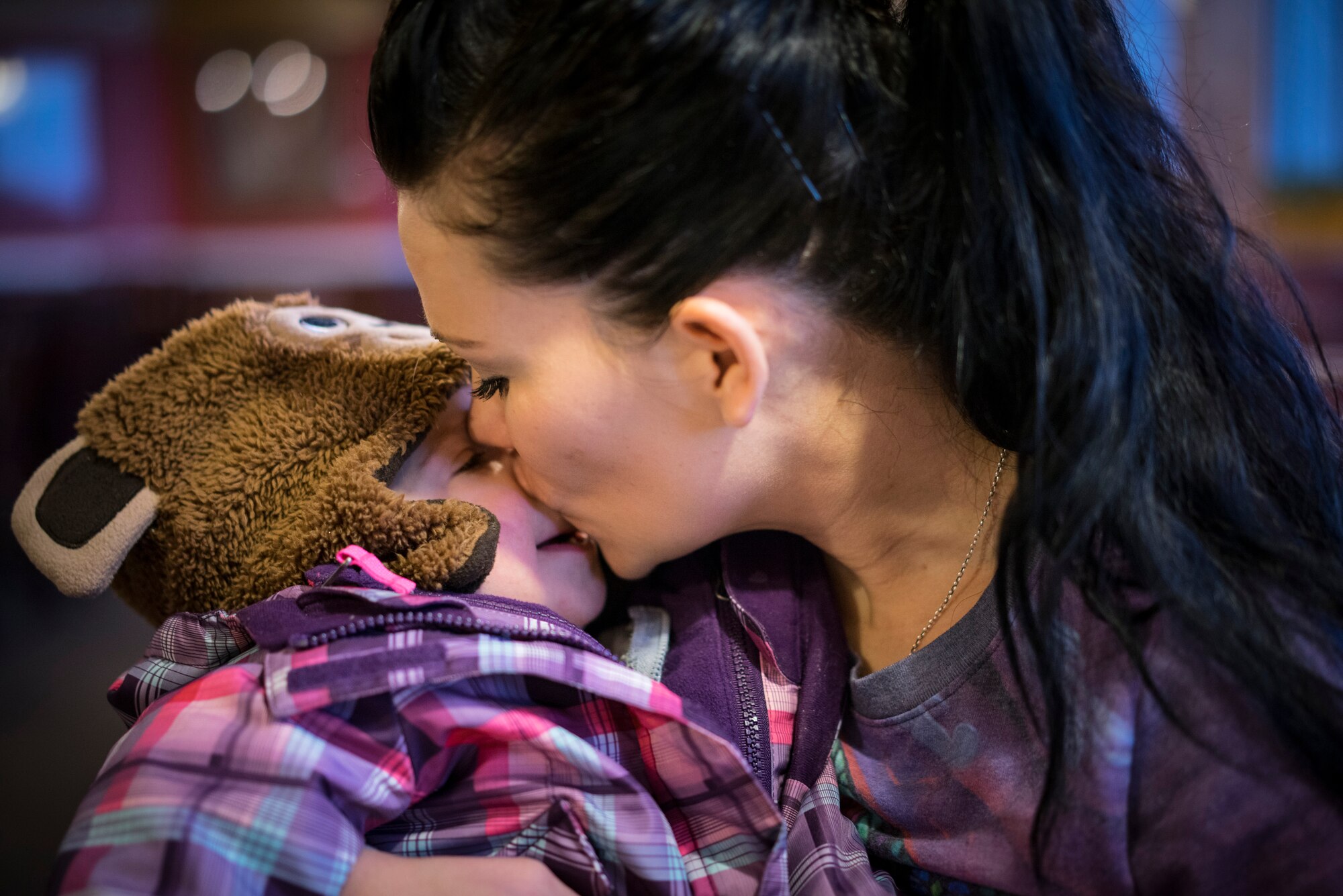 Tech. Sgt. Jamie Meadows-Valley kisses Oleksandra after helping her put her coat on at a restaurant in Mountain Home, Idaho. (U.S. Air Force photo/Tech. Sgt. Samuel Morse)