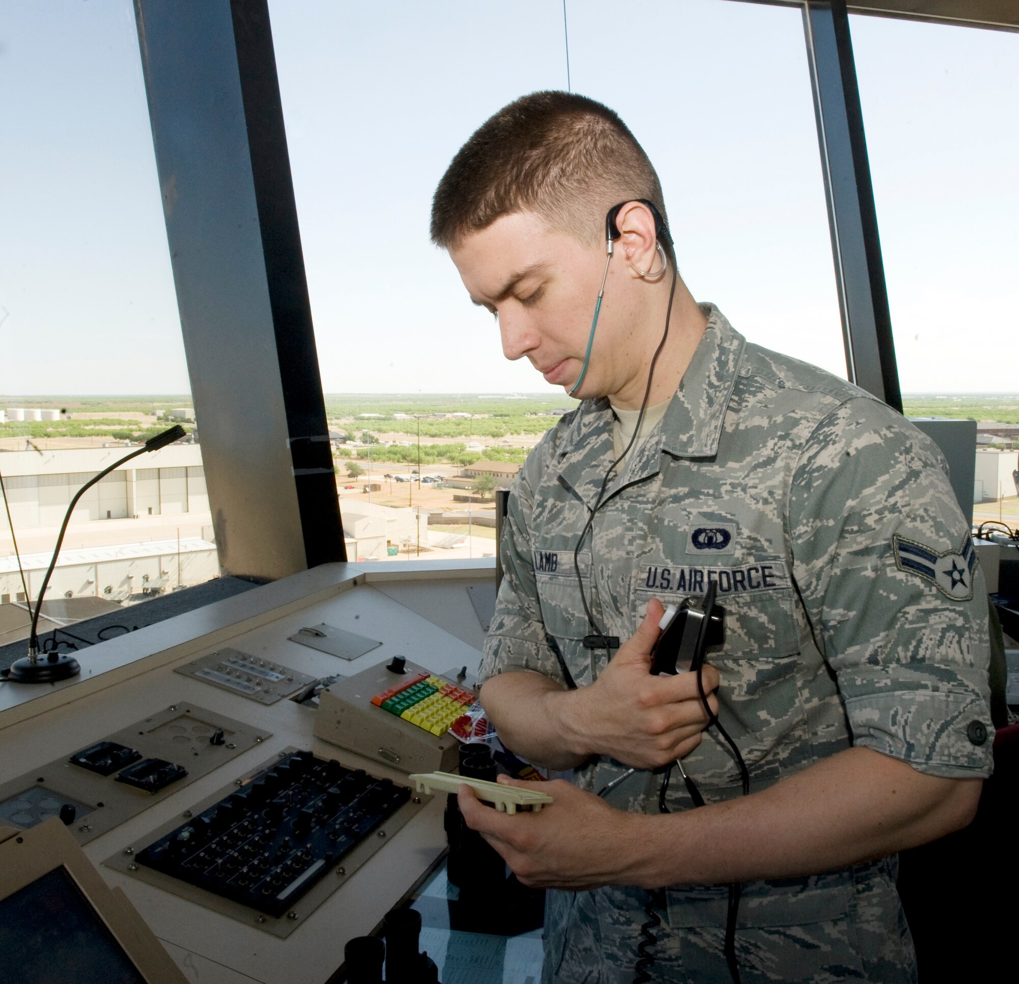 U.S. Air Force Airman 1st Class Tyler Lamb, 7th Operations Support Squadron air traffic controller, reads a clearance to a C-130J Super Hercules pilot from the control tower on May 9, 2014, at Dyess Air Force Base, Texas. Lamb was recently appointed to United States Air Force Academy Preparatory School, where he will increase his chances of being accepted to the Academy at a later date. (U.S. Air Force photo by Airman 1st Class Autumn Velez/Released)