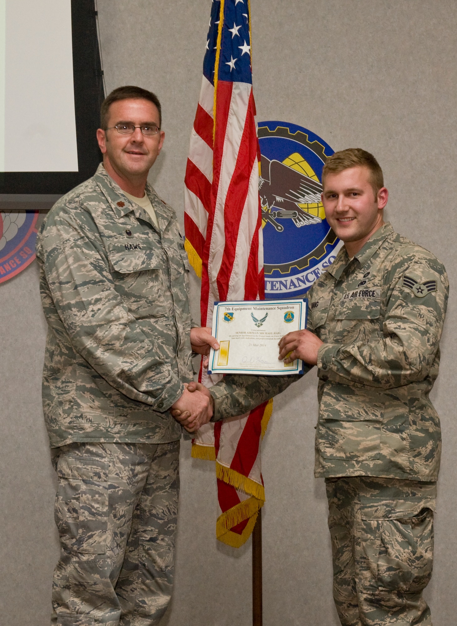 U.S. Air Force Maj. Brian Haws, left, 7th Equipment Maintenance Squadron commander, presents Senior Airman Michael Haig, 7th EMS Aerospace Ground Equipment Flight, with a certificate after being accepted to the United States Air Force Academy Preparatory School on April 16, 2014, at Dyess Air Force Base, Texas. Haig was appointed to the Air Force Academy Preparatory School through the Leaders Encouraging Airmen Development Program, which allows enlisted members to attend the Academy. (U.S. Air Force photo by Airman 1st Class Autumn Velez/Released)