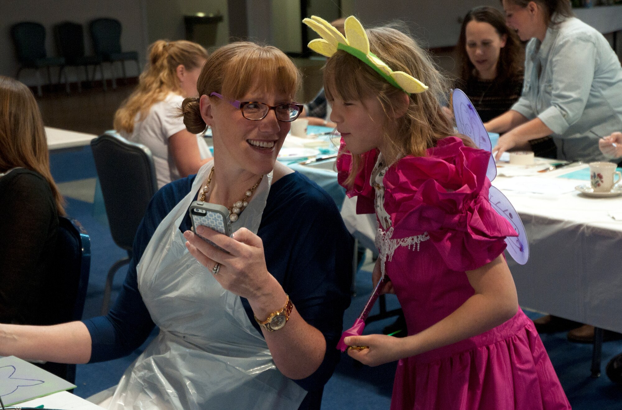 Kellie Picinni shows her daughter, Kaitlynn, 7, a photo she took of Kaitlynn in her costume May 10 during the Mommy and Me Tea and Craft event in the Fall Hall Community Center. (U.S. Air Force photo by Airman Malcolm Mayfield)