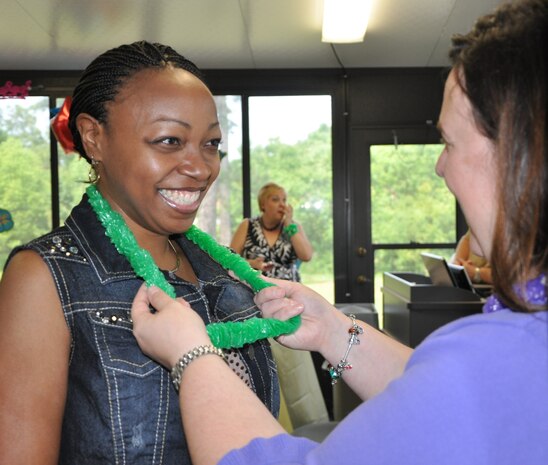 Stephanie Johnson, Naval Health Clinic Charleston Ombudsman and wife of
Chief Petty Officer Anthony Johnson, receives a Hawaiian lei from Beth Darius, Joint Base Charleston – Weapons Station Ombudsman coordinator, as she enters the Fleet & Family Support Center to attend a Cake and Ice Cream Social May 9, 2014, in honor of Military Spouse Appreciation Month. (U.S. Navy photo/Kris Patterson)
