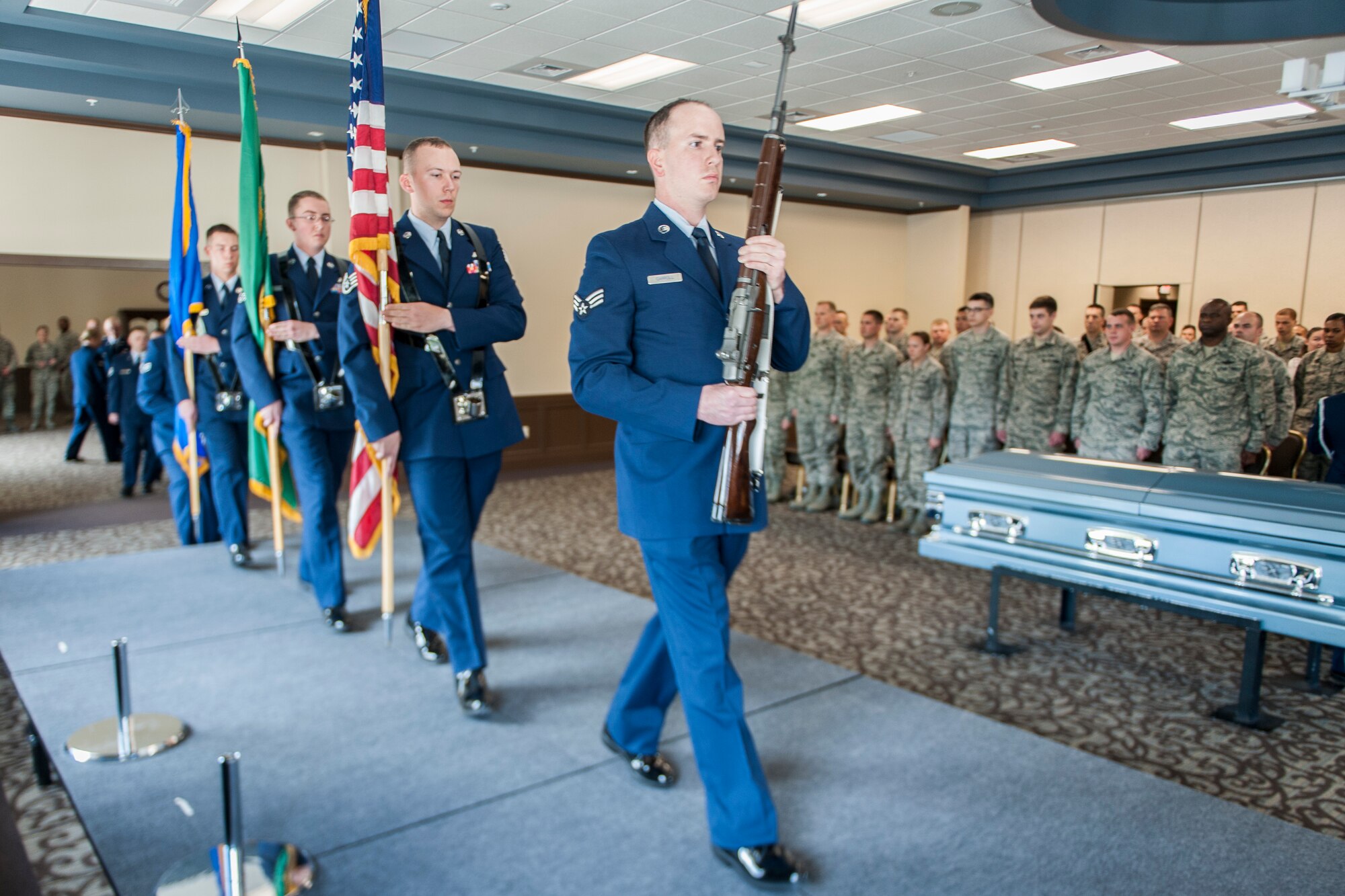 Fairchild Honor Guard graduates performing color guard duty present the colors as part of a military funeral presentation during their graduation ceremony in the Red Morgan Event Center at Fairchild Air Force Base, Wash., May 9, 2014. Fairchild’s honor guard performs military honors for various events and ceremonies across the Inland Northwest every week as the installation’s front-line ambassadors. Each member from nearly every career field serves a four month rotation. (U.S. Air Force photo by Staff Sgt. Benjamin W. Stratton/Released)