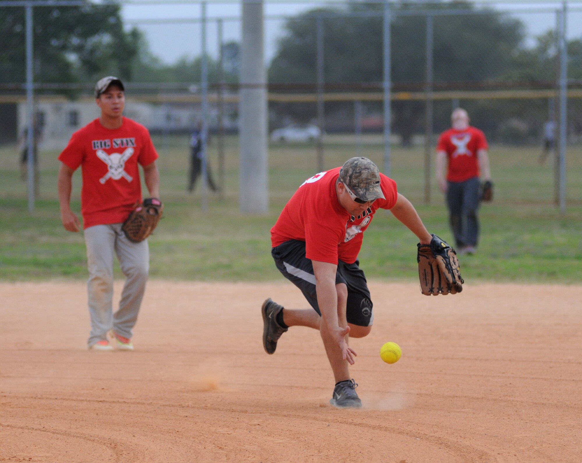 Isidro Saladana, 81st Surgical Operations Squadron third baseman, struggles to grasp the ball during an intramural softball game against 81st Contracting Squadron May 8, 2014, at Keesler Air Force Base, Miss.  81st CONS defeated 81st MSGS, 14-5. (U.S. Air Force photo by Kemberly Groue)