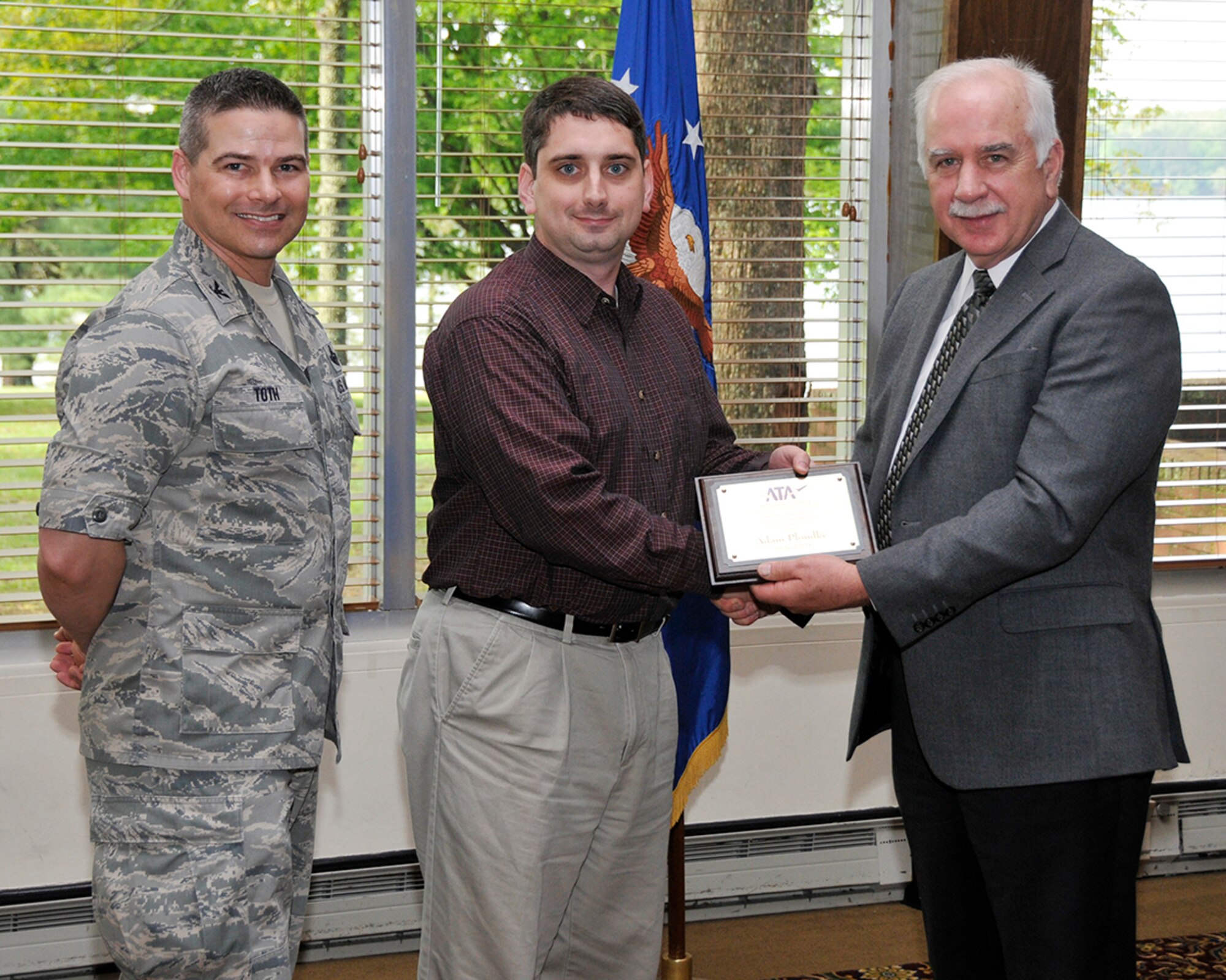 Adam Plondke (center) accepts his ATA Internal Customer Service Excellence Award from ATA General Manager Steve Pearson (right) and AEDC Commander Col. Raymond Toth. (Photo by Rick Goodfriend)