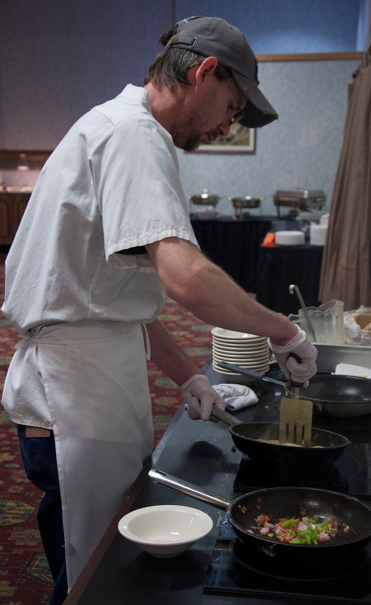 140510-F-GZ967-015 Shawn Massey, 90th Force Support Squadron chef, cooks up an omelet during the Mother’s Day Brunch May 10 in the Trail’s End Club. A wide variety of breakfast and lunch food choices were available for attendees, including freshly carved ham, waffles and chicken tenders. (U.S. Air Force photo by Airman 1st Class Brandon Valle)