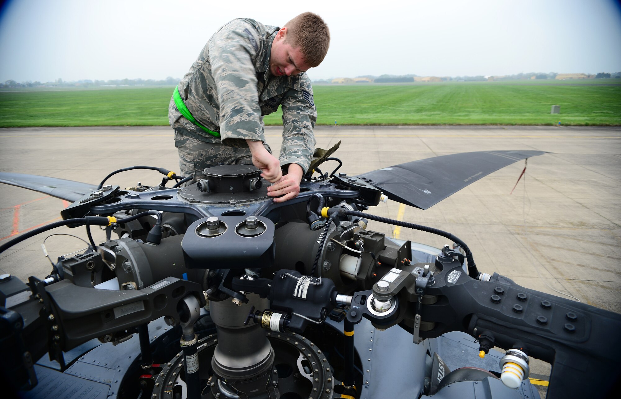 Staff Sgt. Adam Griffin, 748th Aircraft Maintenance Squadron flying crew chief, removes a main rotor de-ice cover to conduct torque checks on an HH-60G Pave Hawk at Royal Air Force Leeming, England, April 30, 2014. While 56th Rescue Squadron pilots were training to fight in contested environments, maintenance Airmen ensured their aircraft were always in alert status and prepared to fly at a moment’s notice. (U.S. Air Force photo by Staff Sgt. Emerson Nuñez/Released)