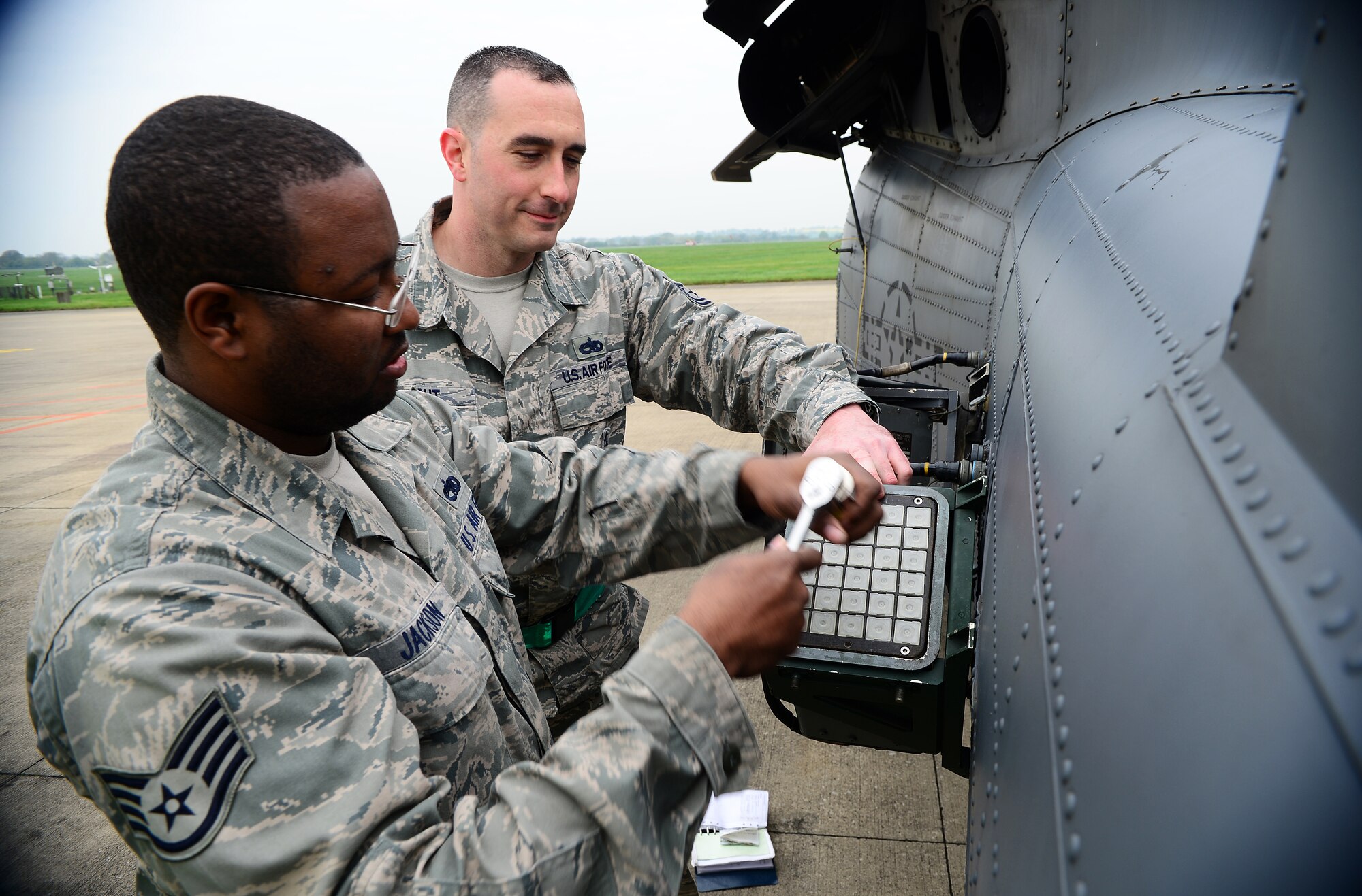 Staff Sgt. Thomas Jackson, and Tech. Sgt. Mathew Wright, load chaff on an HH-60G Pave Hawk at Royal Air Force Leeming, England, April 30, 2014. Jackson is a 748th Aircraft Maintenance Squadron weapon load crew team chief and Wright is a 748th AMXS weapons expeditor. Maintenance Airmen conduct routine maintenance checks before and after flights to ensure minimal delays before takeoff. (U.S. Air Force photo by Staff Sgt. Emerson Nuñez/Released) 