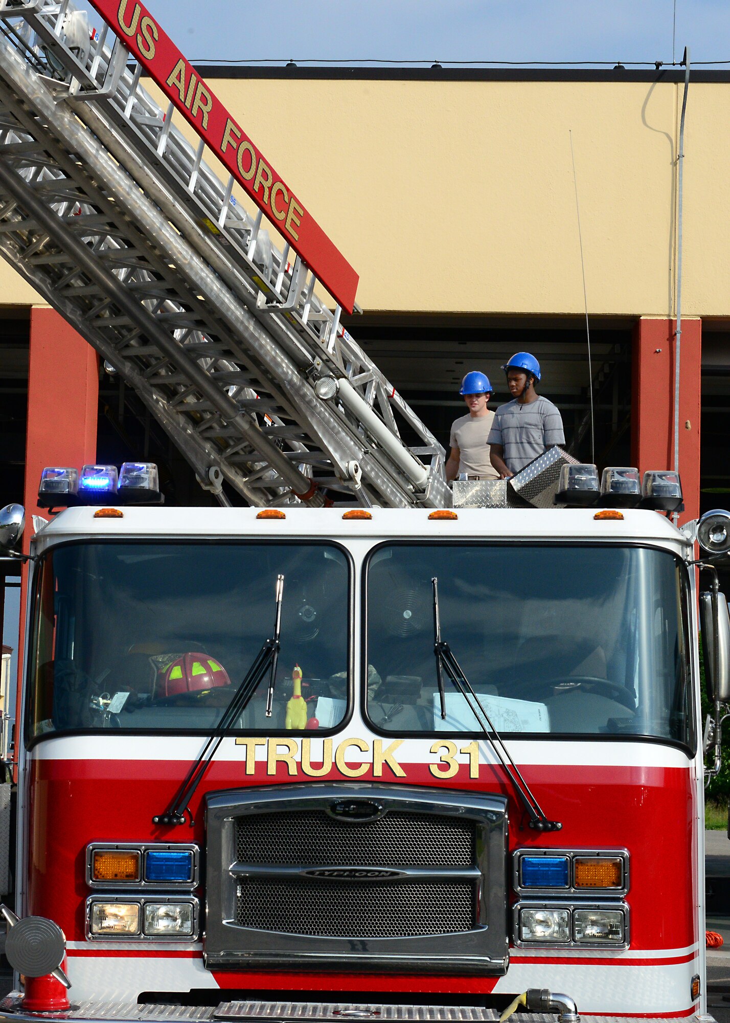 (From left) Airman 1st Class Joseph Cappell, 31st Civil Engineering Squadron firefighter, and Chase Cottingham, Aviano High School 10th grade student, operate the ladder on a firetruck, May 9, 2014, at Aviano Air Base, Italy. In an effort to create a realistic connection between the classroom and the workforce, Aviano Middle/High School students and young dependents shadowed Airmen from several different career fields. (U.S. Air Force photo/Airman 1st Class Ryan Conroy) 