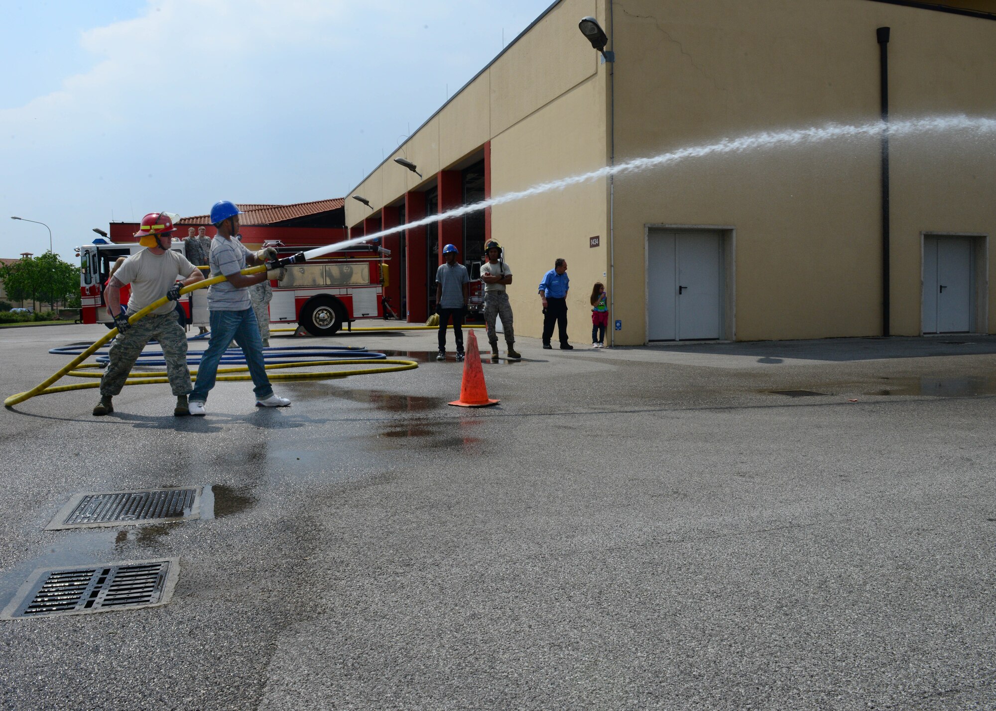 (From left) Staff Sgt. Christopher Chaves, 31st Civil Engineer Squadron firefighter, and Chase Cottingham, Aviano High School 10th grade student, spray a fire hose during an annual job shadow day, May 9, 2014, at Aviano Air Base, Italy. Throughout the day, students exercised classroom instruction and applied it to various workplace procedures through active participation. (U.S. Air Force photo/Airman 1st Class Ryan Conroy) 