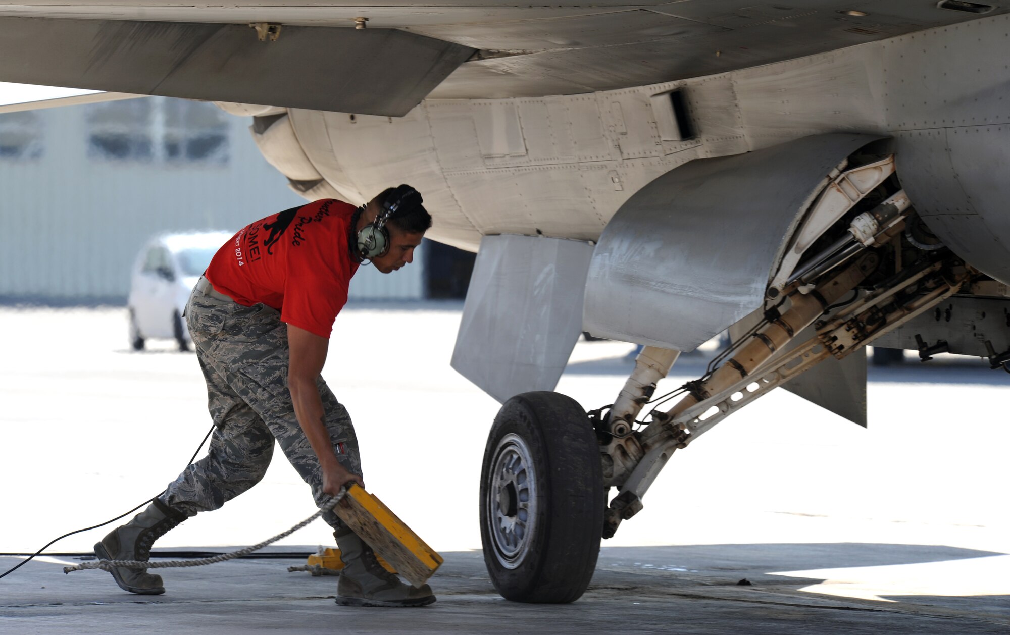 U.S. Air Force Staff Sgt. Hermann Nunez, a crew chief from the 13th Fighter Squadron at Misawa Air Base, Japan, puts chocks under the wheel of an F-16 Fighting Falcon during a scramble competition at Exercise Eager Tiger May 12, 2014, at an air base in northern Jordan. Nunez and his team faced off against crews from the U.S. Marine Corps and Royal Jordanian Air Force. (U.S. Air Force photo by Staff Sgt. Brigitte N. Brantley/Released)
