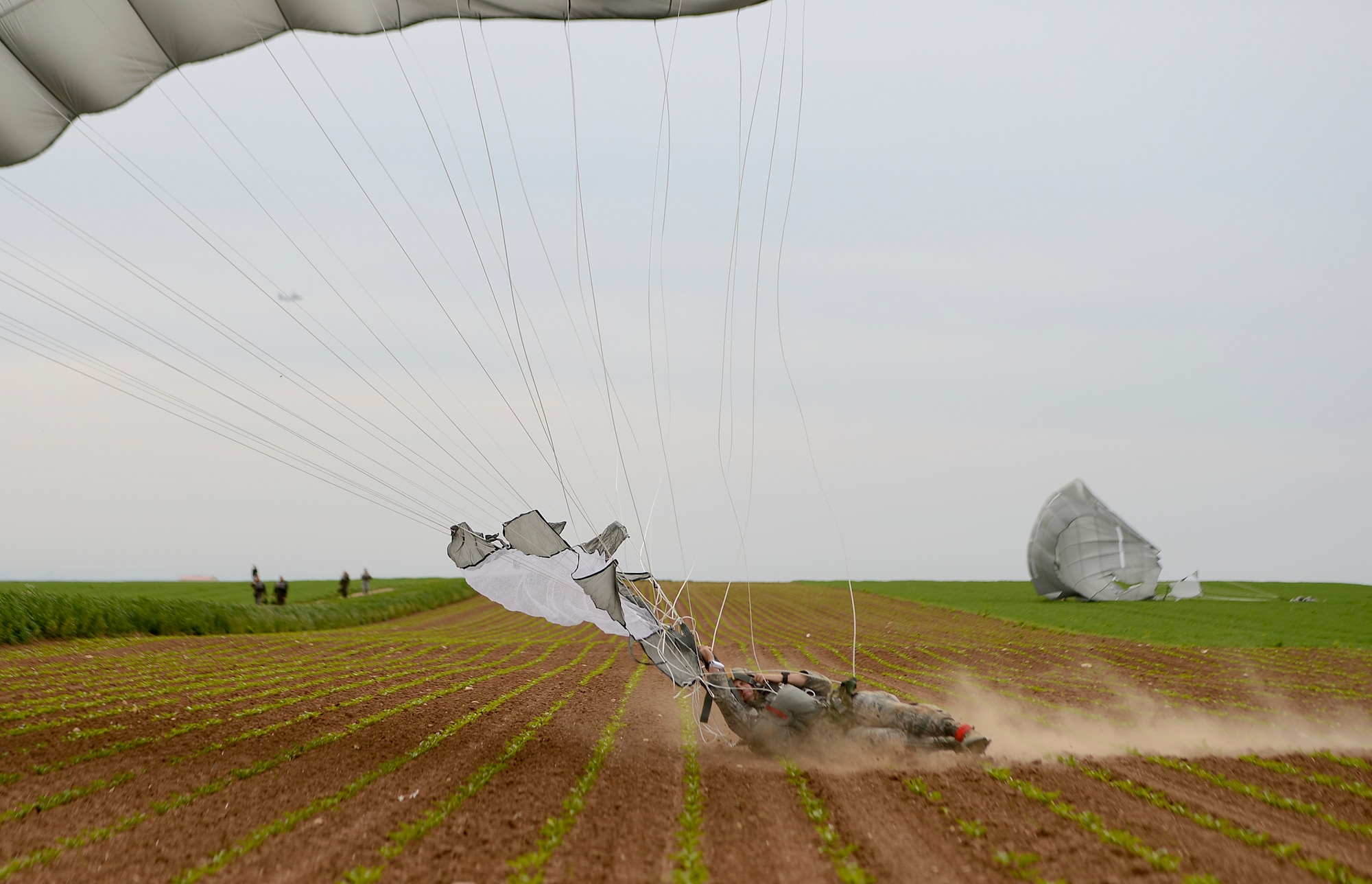 A U.S. Air Force jumpmaster is dragged several yards across the ground as he lands from a 1,250 ft static-line jump during International Jump Week in Alzey landing zone, Germany, May 5th, 2014. During the week, winds made it hard for jumpers to land, but the inclement weather wasn’t enough to stop them from completing the mission. (U.S. Air Force photo/Airman 1st Class Michael Stuart) 