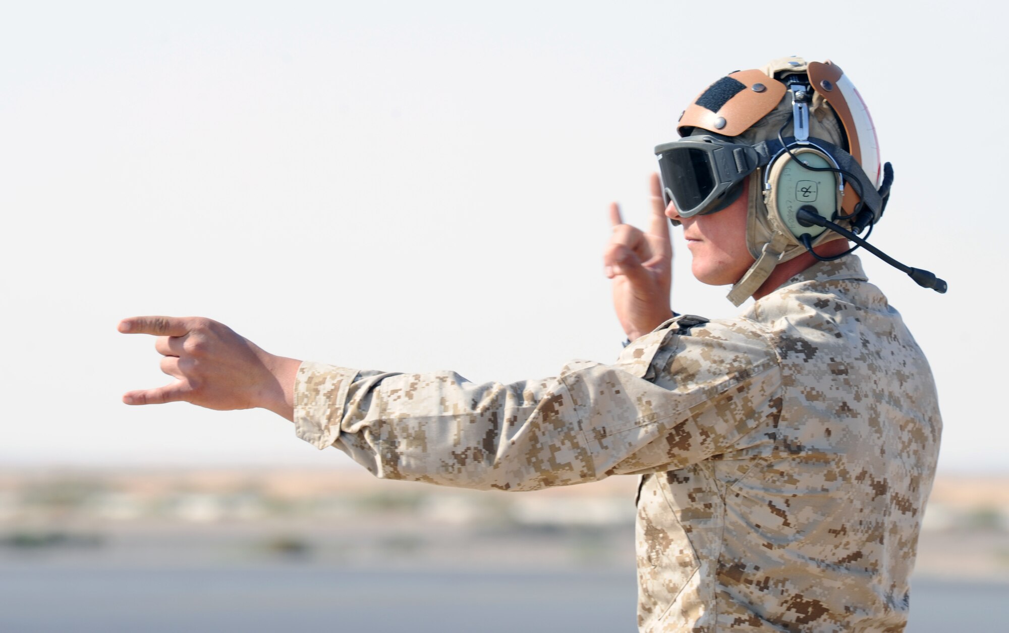 A member assigned to Marine Air Group 50 at Marine Corps Air Station Miramar, Calif., marshals an F-18 Hornet for takeoff during a scramble competition at Exercise Eager Tiger May 12, 2014, at an air base in northern Jordan. Marines rushed to beat F-16 Fighting Falcon crews from the U.S. Air Force and Royal Jordanian Air Force. (U.S. Air Force photo by Staff Sgt. Brigitte N. Brantley/Released)