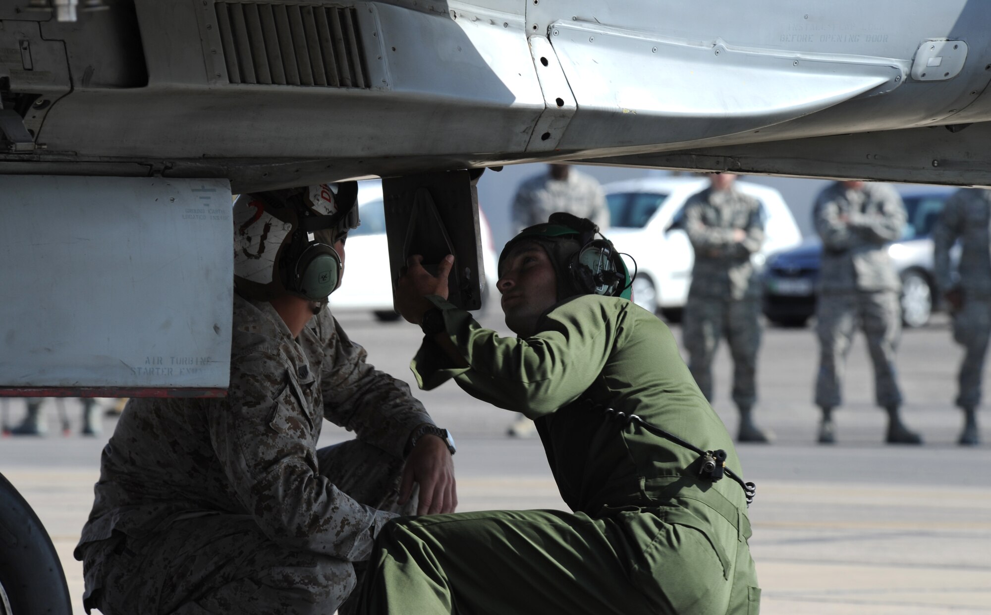 Members assigned to the Marine Air Group 50 at Marine Corps Air Station Miramar, Calif., prepare an F-18 Hornet for takeoff during a scramble competition at Exercise Eager Tiger May 12, 2014, at an air base in northern Jordan. The Marines competed against F-16 Fighting Falcon crews from the U.S. Air Force and Royal Jordanian Air Force. (U.S. Air Force photo by Staff Sgt. Brigitte N. Brantley/Released)