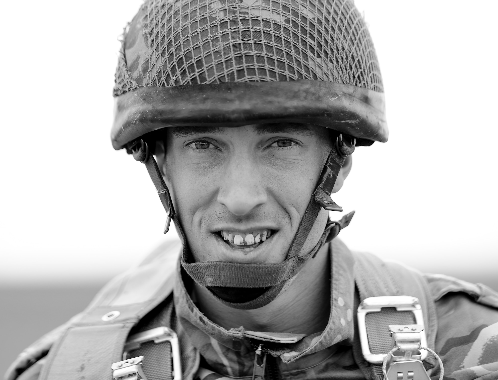 British Royal Air Force Regiment, Corporal Alan Pownall smiles with a mouth full of soil as he gets up from a harsh landing during International Jump Week in Alzey landing zone, Germany, May 6th, 2014. During the week, more than 300 members from nine nations, including the U.S., completed a total of 404 static-line jumps and 132 high-altitude low-opening jumps in three days. (U.S. Air Force photo/Airman 1st Class Michael Stuart)