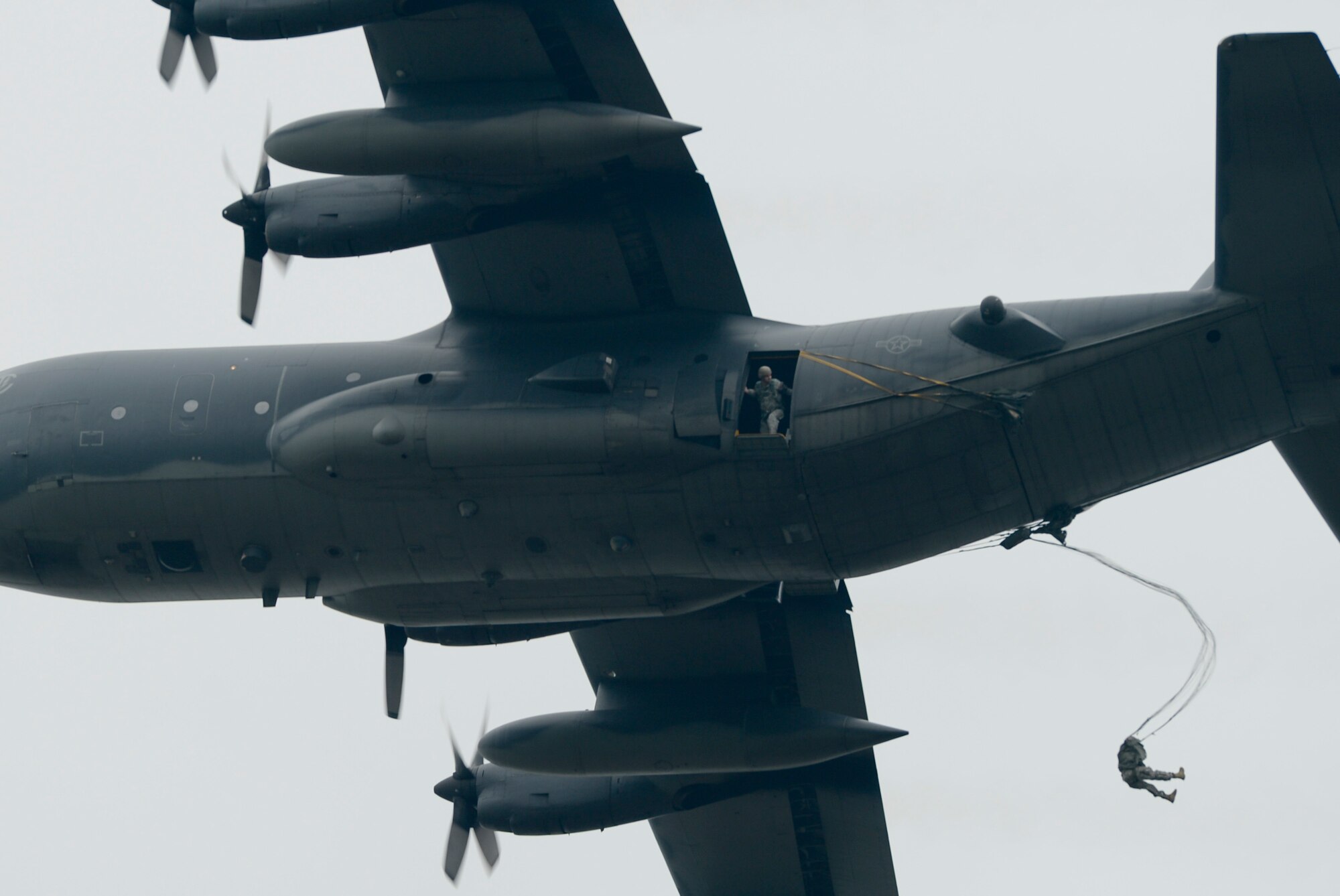 An Airman exits a C-130H during International Jump Week in Alzey landing zone, Germany, May 6th, 2014. During the week, more than 300 members from nine nations, including the U.S., completed a total of 404 static-line jumps and 132 high-altitude low-opening jumps in three days. (U.S. Air Force photo/Airman 1st Class Michael Stuart)
