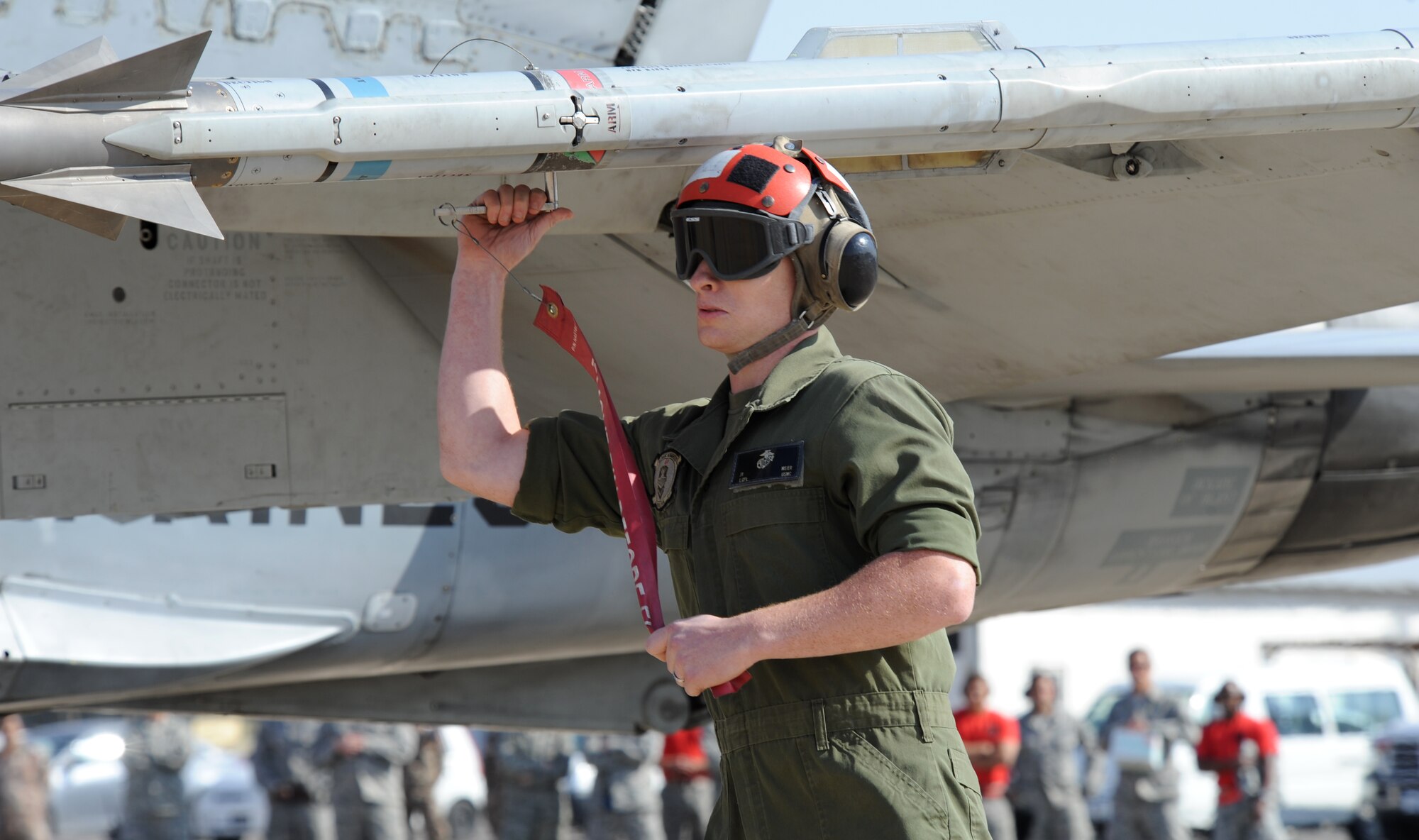A member assigned to Marine Air Group 50 at Marine Corps Air Station Miramar, Calif., prepares an F-18 Hornet for takeoff during a scramble competition at Exercise Eager Tiger May 12, 2014, at an air base in northern Jordan. Service members from the U.S. and Jordanian militaries participated in friendly competitions throughout the exercise to build partnership and camaraderie. (U.S. Air Force photo by Staff Sgt. Brigitte N. Brantley/Released)