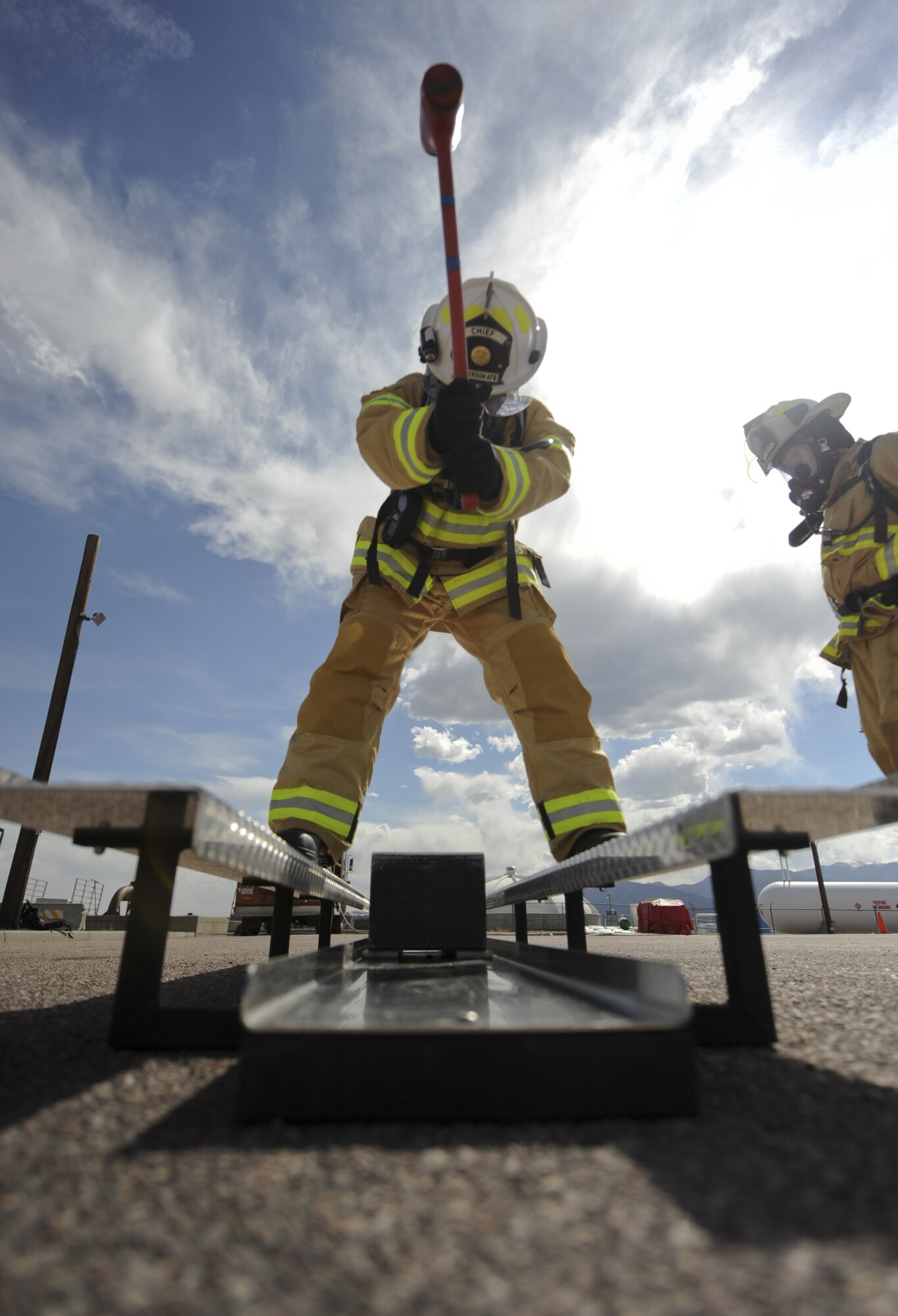 PETERSON AIR FORCE BASE, Colo. – Chief Master Sgt. Mark Crowe, 21st Civil Engineer Squadron chief, swings a sledgehammer moving a heavy block down an apparatus designed to simulate tearing a hole in a roof for ventilation May 9 here. The simulation of ventilating a roof is one of six obstacles in the unofficial firefighter endurance test the 21st CES fire protection teams go through at least semiannually. (U.S. Air Force photo/Staff Sgt. Jacob Morgan)