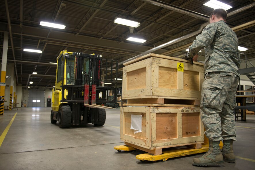 Airmen from the 5th Logistics Readiness Squadron traffic management office assemble crates and label cargo for shipment at Minot Air Force Base, N.D., April 30, 2014. TMO is responsible for packaging and shipping furnished goods to other bases around the world. In addition to receiving and shipping Airmen’s household goods, TMO also assists with the shipment and packaging of mission essential parts and components. (U.S. Air Force photo/Airman 1st Class Sahara L. Fales) 