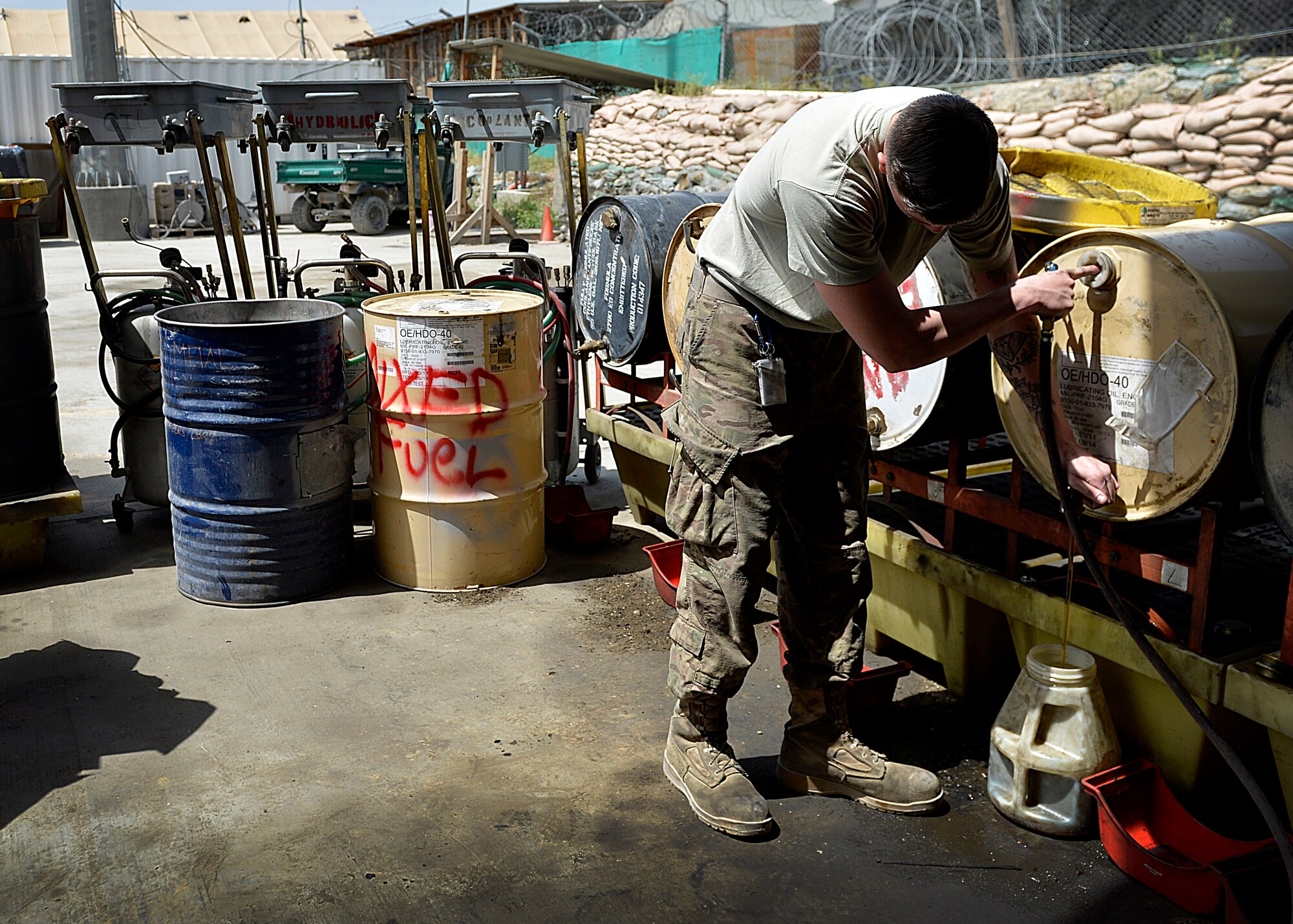 Senior Airman Michael Sitters, 455th Expeditionary Logistics Readiness Squadron vehicle maintenance journeyman pours oil in a container May 7, 2014 at Bagram Airfield, Afghanistan.  As a vehicle maintainer at here, Sitters helps ensure more than 350 vehicles are operational and ready for their daily mission.  Sitters is deployed from Yokota Air Base, Japan and a native of Port St. Lucie, Fla. (U.S. Air Force photo by Staff Sgt. Evelyn Chavez/Released)