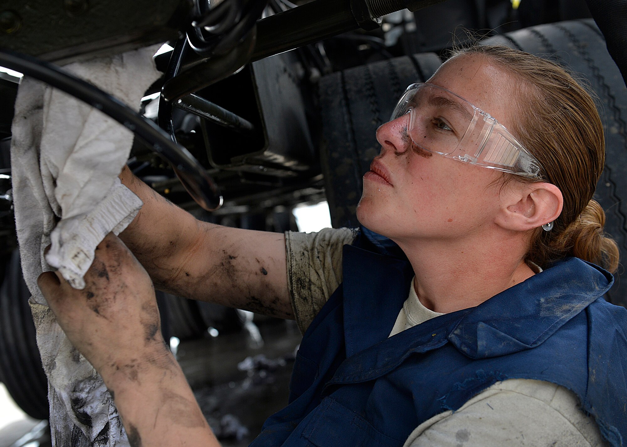 Staff Sgt. Alyssa Sutton, 455th Expeditionary Logistics Readiness Squadron vehicle maintenance material handling equipment mechanic, wipes grease off a truck May 7, 2014 at Bagram Airfield, Afghanistan.  As a vehicle maintainer, Sutton is trained to repair, inspect and maintain vehicles that are essential to the daily mission.  Sutton is deployed from Altus Air Force Base, Okla. and a native of Hudson S.D.  (U.S. Air Force photo by Staff Sgt. Evelyn Chavez/Released)