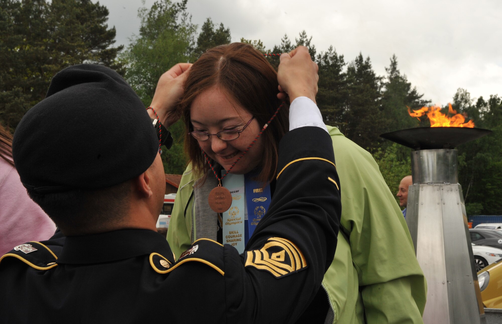 Jessica Lawrence, daughter of Army Lt. Col. Ryan Lawrence, receives a medal after participating in the 2014 Spring Special Olympics on Pulaski Park, May 9, 2014. This year’s Special Olympics consisted of events such as track and field, soccer, volleyball, basketball, softball, arts and crafts and karaoke; there were also non-competitive events for children ages five to seven who weren’t able compete yet according to the rules. (U.S. Air Force photo/Senior Airman Hailey Haux)
