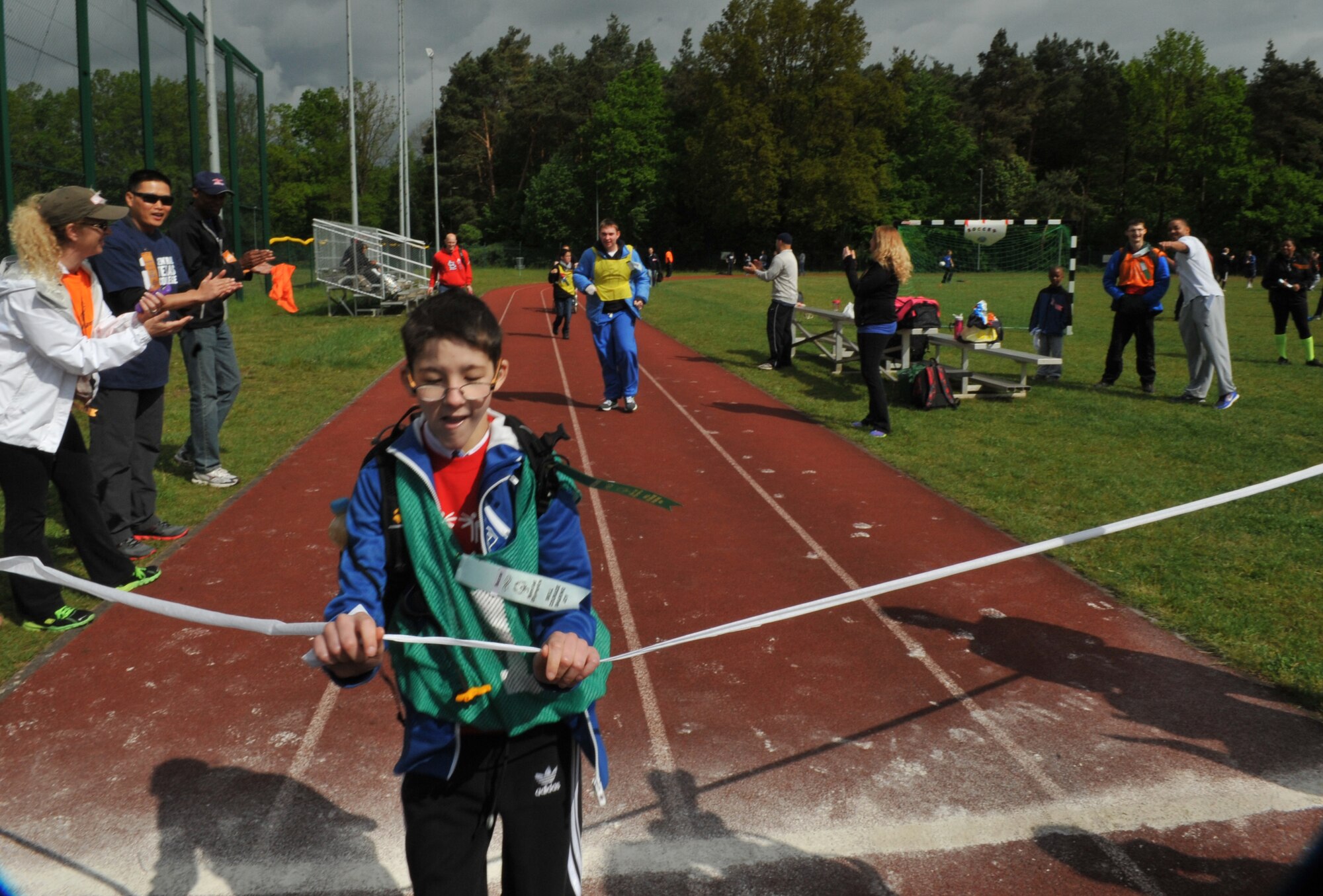An athlete runs through the finish line during the 2014 Spring Special Olympics began in Pulaski Park, May 9, 2014. This year’s Special Olympics consisted of events such as track and field, soccer, volleyball, basketball, softball, arts and crafts and karaoke; there were also non-competitive events for children ages five to seven who weren’t able compete yet according to the rules. (U.S. Air Force photo/Senior Airman Hailey Haux)