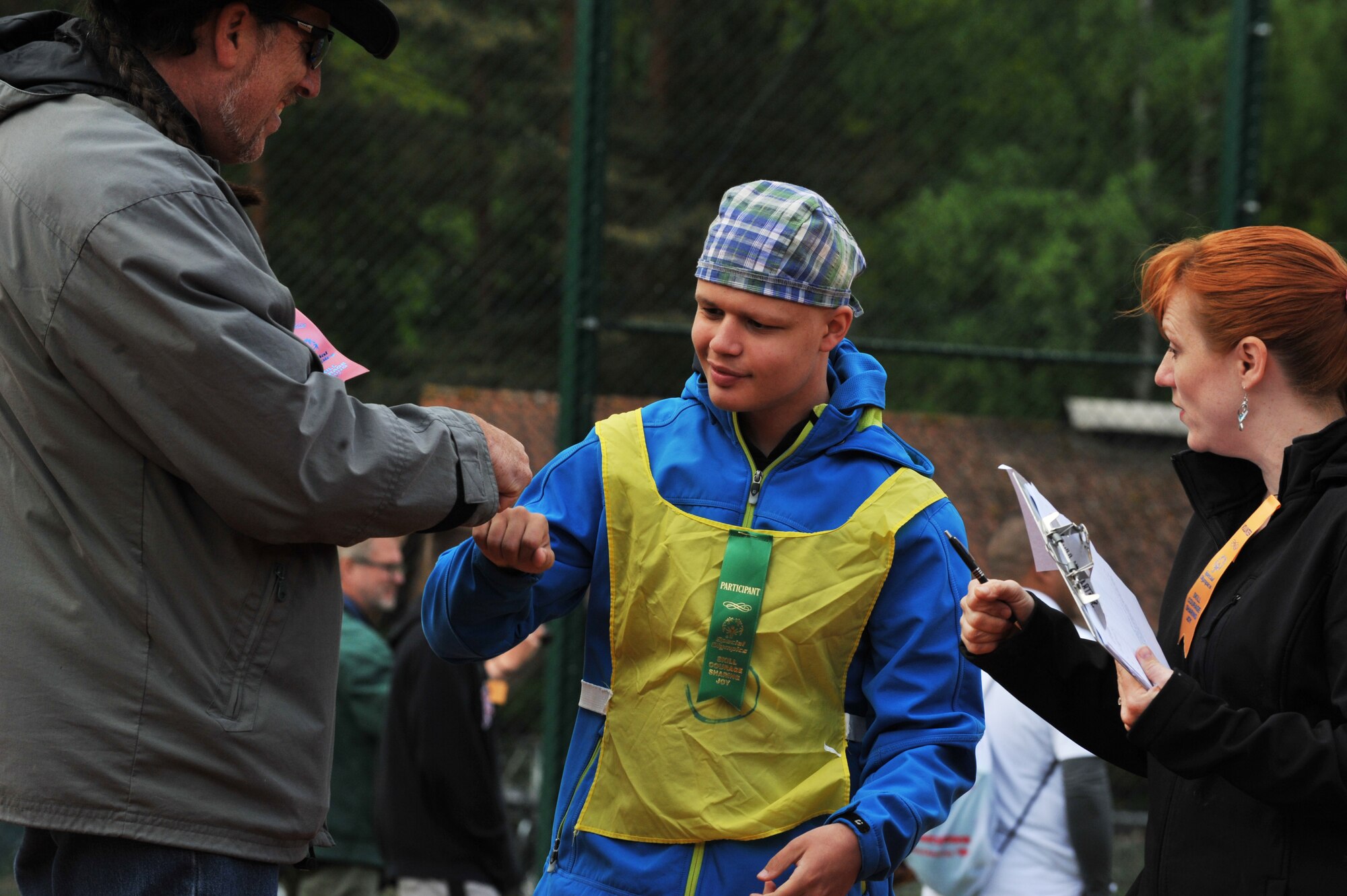 Johnny Karaca, son of retired Army Metin Karaca, gives his buddy a fist bump during the 2014 Spring Special Olympics began in Pulaski Park, May 9, 2014. This year’s Special Olympics consisted of events such as track and field, soccer, volleyball, basketball, softball, arts and crafts and karaoke; there were also non-competitive events for children ages five to seven who weren’t able compete yet according to the rules. (U.S. Air Force photo/Senior Airman Hailey Haux)