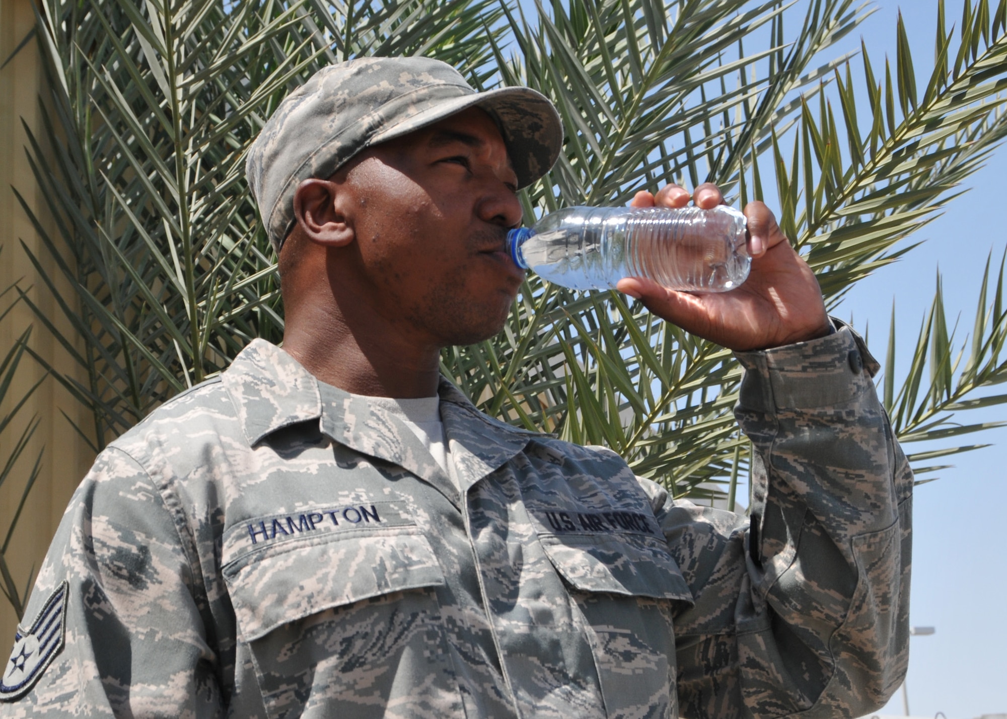 Air Force Staff Sgt. Willie Hampton, 380th Expeditionary Medical Group bioenvironmental engineering technician, takes a drink of fresh water during the heat of the day at an undisclosed location in Southwest Asia May 7, 2014. (U.S. Air Force photo by Senior Master Sgt. Eric Peterson/Released)