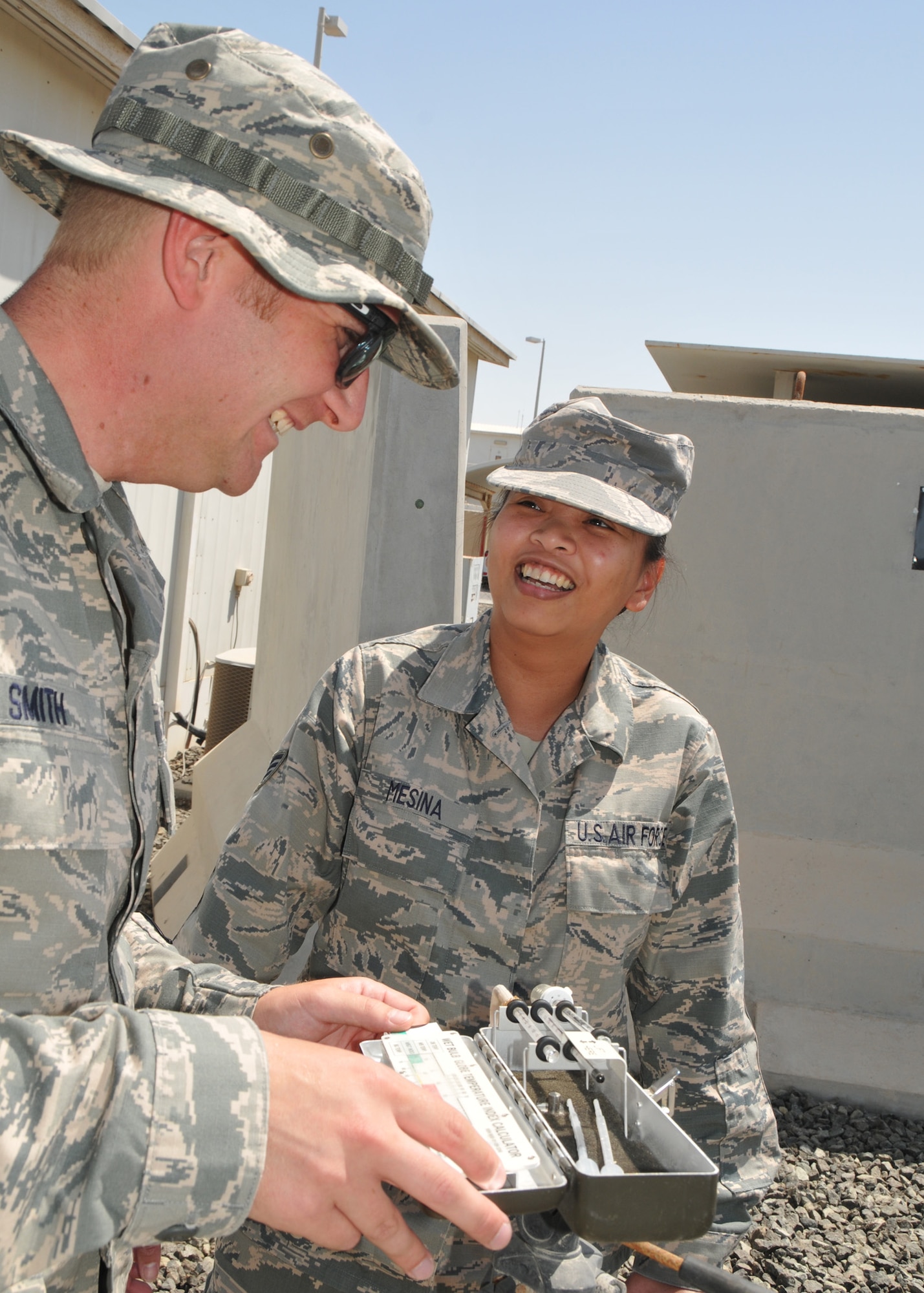 Air Force Staff Sergeants Jonathan Smith and Sarah-Jane Mesina, 380th Expeditionary Medical Group bioenvironmental engineering technicians, check the wet bulb temperature at an undisclosed location in Southwest Asia May 7, 2014.  (U.S. Air Force photo by Senior Master Sgt. Eric Peterson/Released)