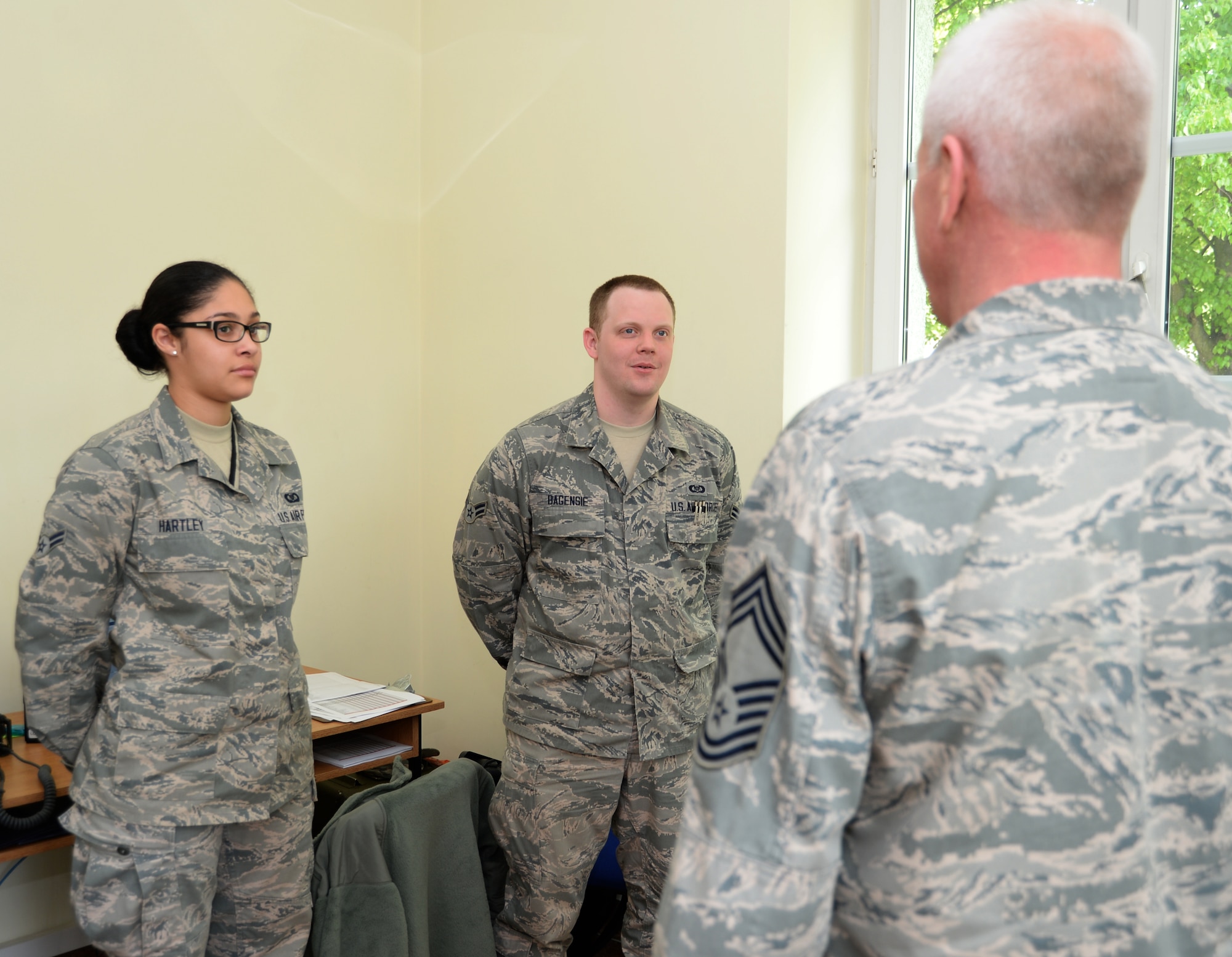 U.S. Air Force Airmen 1st Class Victoria Hartley, a 480th Fighter Squadron aviation resource manager and Royal Air Force Alconbury, United Kingdom, native, left, and Aleczander Bagensie, a 480th FS aviation resource manager and Moore, Okla., native, center, listen as Chief Master Sgt. Bruce Zahn, 52nd Operations Group chief enlisted manager, speaks with them at Łask Air Base, Poland, May 7, 2014. Zahn visited 480th FS Airmen sent to Łask from their home station at Spangdahlem Air Base, Germany. (U.S. Air Force photo illustration by Staff Sgt. Joe W. McFadden/Released)