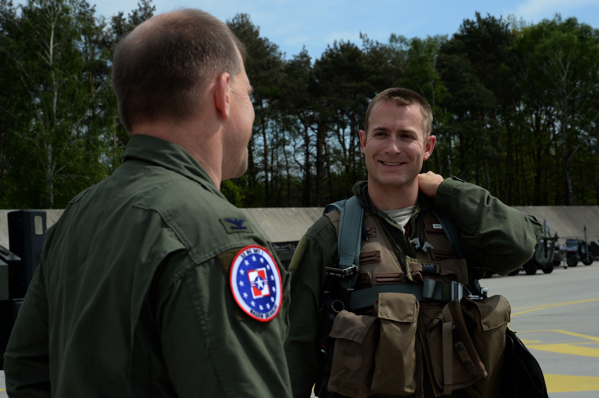 U.S. Air Force Col. Robert Winkler, 52nd Operations Group commander, left, speaks with Capt. Anthony Kiggins, a 480th Fighter Squadron pilot, on the flightline at Łask Air Base, Poland, May 7, 2014. Winkler visited with 480th FS pilots who flew F-16 Fighting Falcon aircraft from their home station at Spangdahlem Air Base, Germany, to Łask. (U.S. Air Force photo by Staff Sgt. Joe W. McFadden/Released)