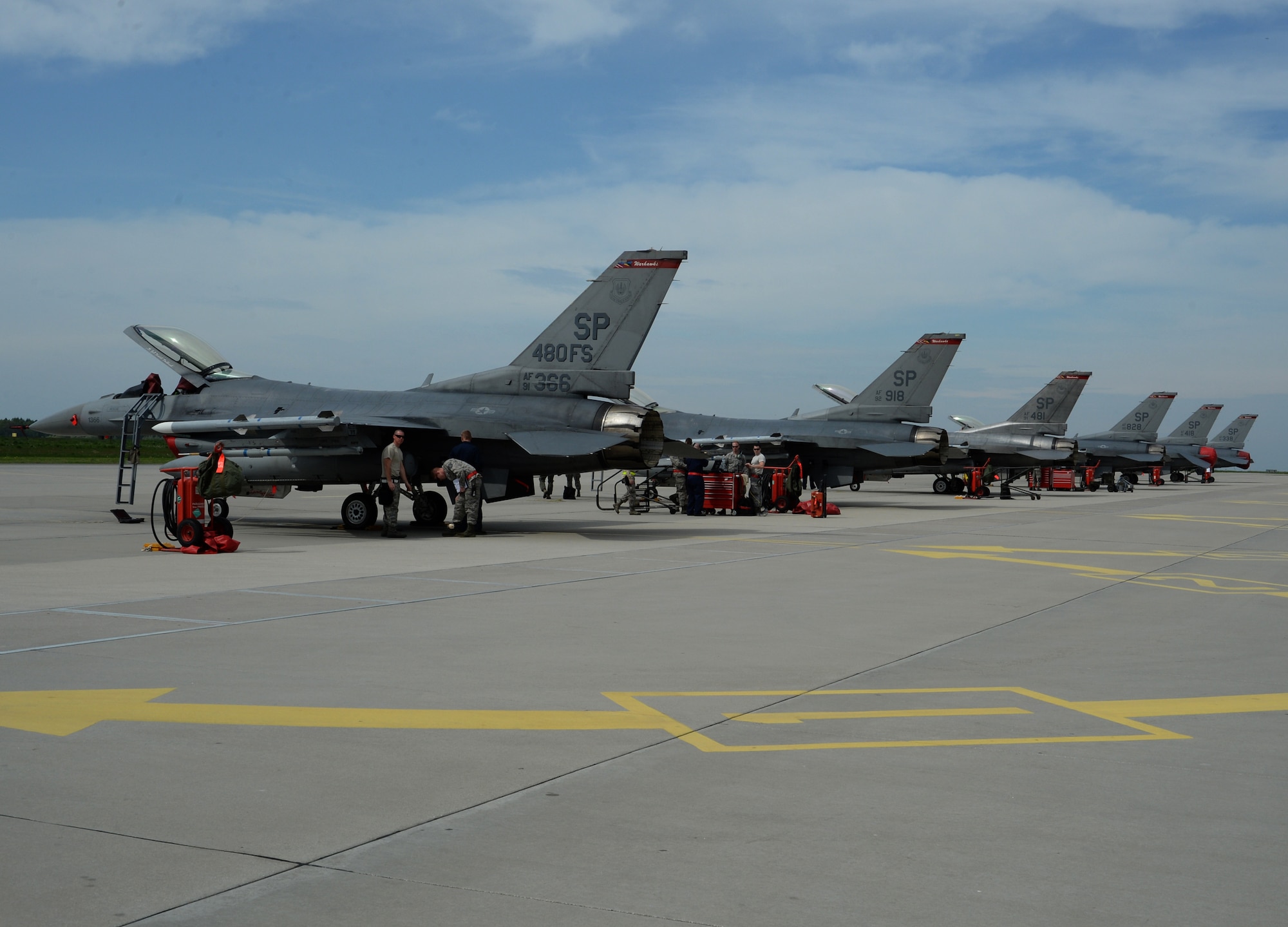 Six F-16 Fighting Falcon fighter aircraft assigned to the 480th Fighter Squadron receive maintenance while on the flightline at Łask Air Base, Poland, May 7, 2014. The 480th FS, known as the Warhawks, maintain a lineage of flying service going back more than 50 years. (U.S. Air Force photo illustration by Staff Sgt. Joe W. McFadden/Released)