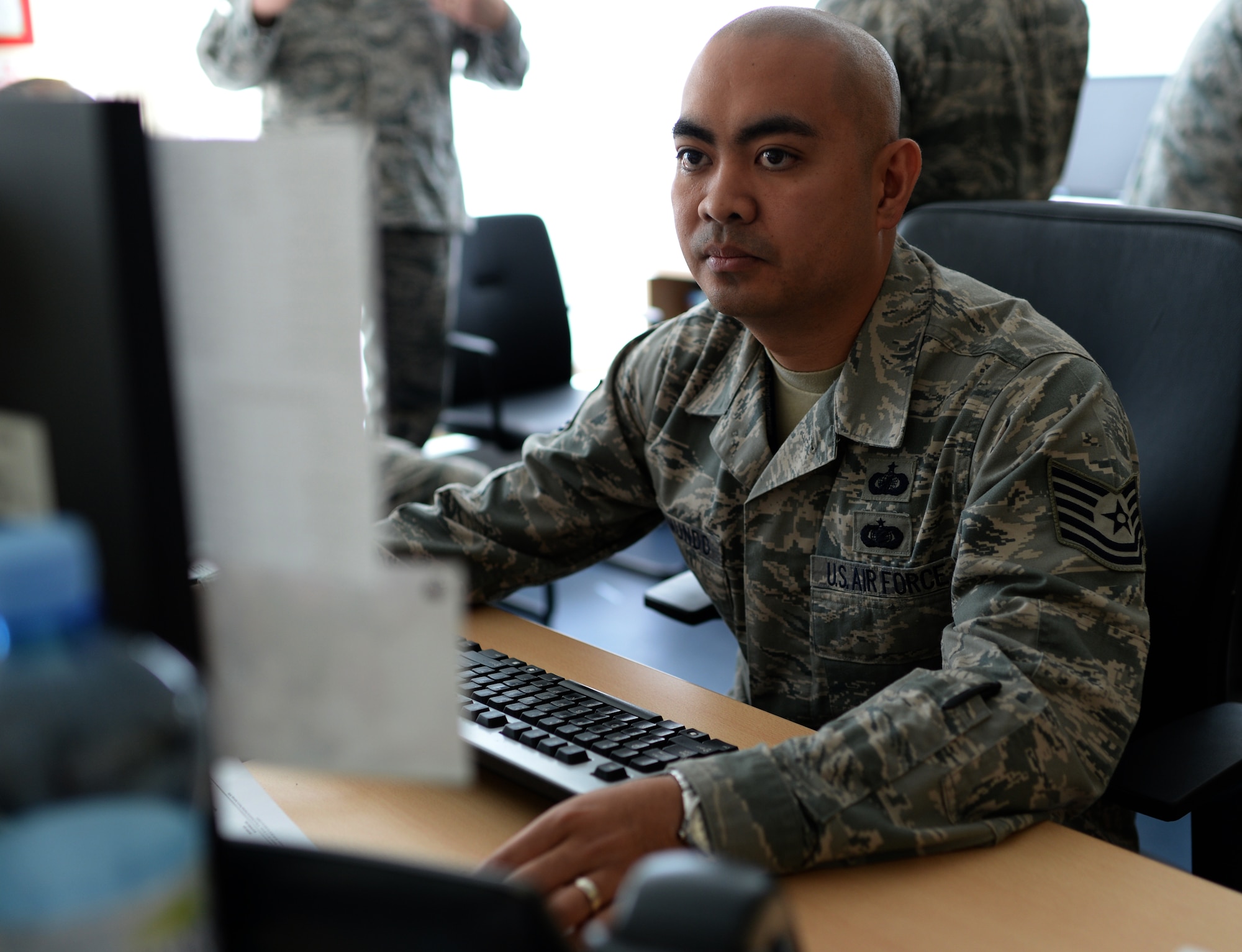 U.S. Air Force Tech. Sgt. Rommel Delmundo, Detachment 1, 52nd Operations Group contracting officer and Las Vegas native, reads an email while at his desk at Łask Air Base, Poland, May 7, 2014. The mission of Detachment 1 serves to foster bilateral defense ties, enhance regional security and increase interoperability among NATO allies through combined training exercises with periodic rotational aircraft. (U.S. Air Force photo by Staff Sgt. Joe W. McFadden/Released)