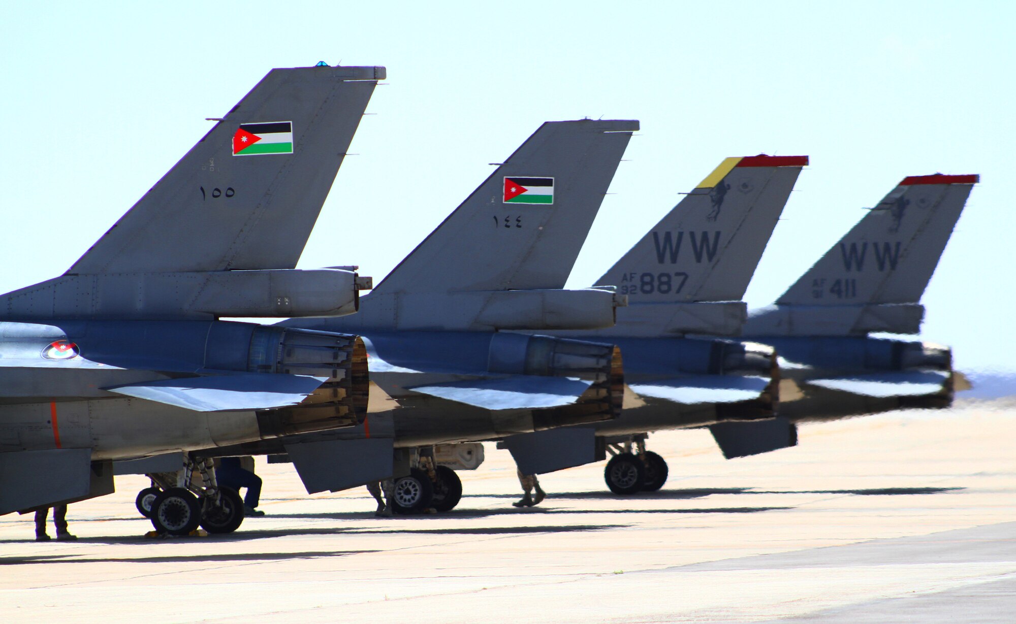F-16 Fighting Falcons from Jordan and the 13th Fighter Squadron at Misawa Air Base, Japan, wait on the flightline to take off and practice defensive counterair measures during the first day of Exercise Eager Tiger May 11, 2014, at an air base in northern Jordan. Each year, the countries come together to have friendly competitions aimed at enhancing their real-life techniques. (U.S. Air Force photo by Staff Sgt. Tyler McLain/Released)