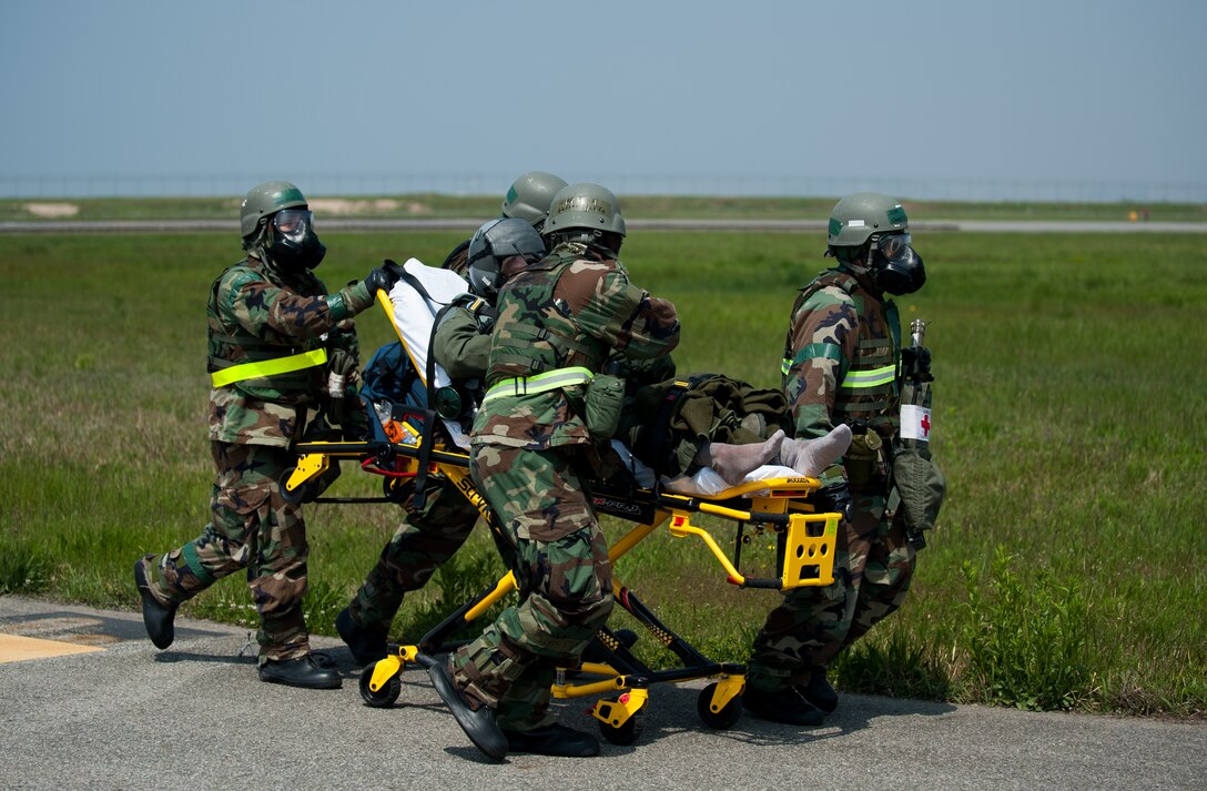 Airmen from the 8th Medical Group transport a simulated contaminated pilot during exercise Beverly Bulldog 14-2 at Kunsan Air Base, Republic of Korea, May 9, 2014. This exercise tested the Wolf Pack's ability to perform its mission while under threat of chemical attack. (U.S. Air Force photo by Staff Sgt. Clayton Lenhardt/Released)