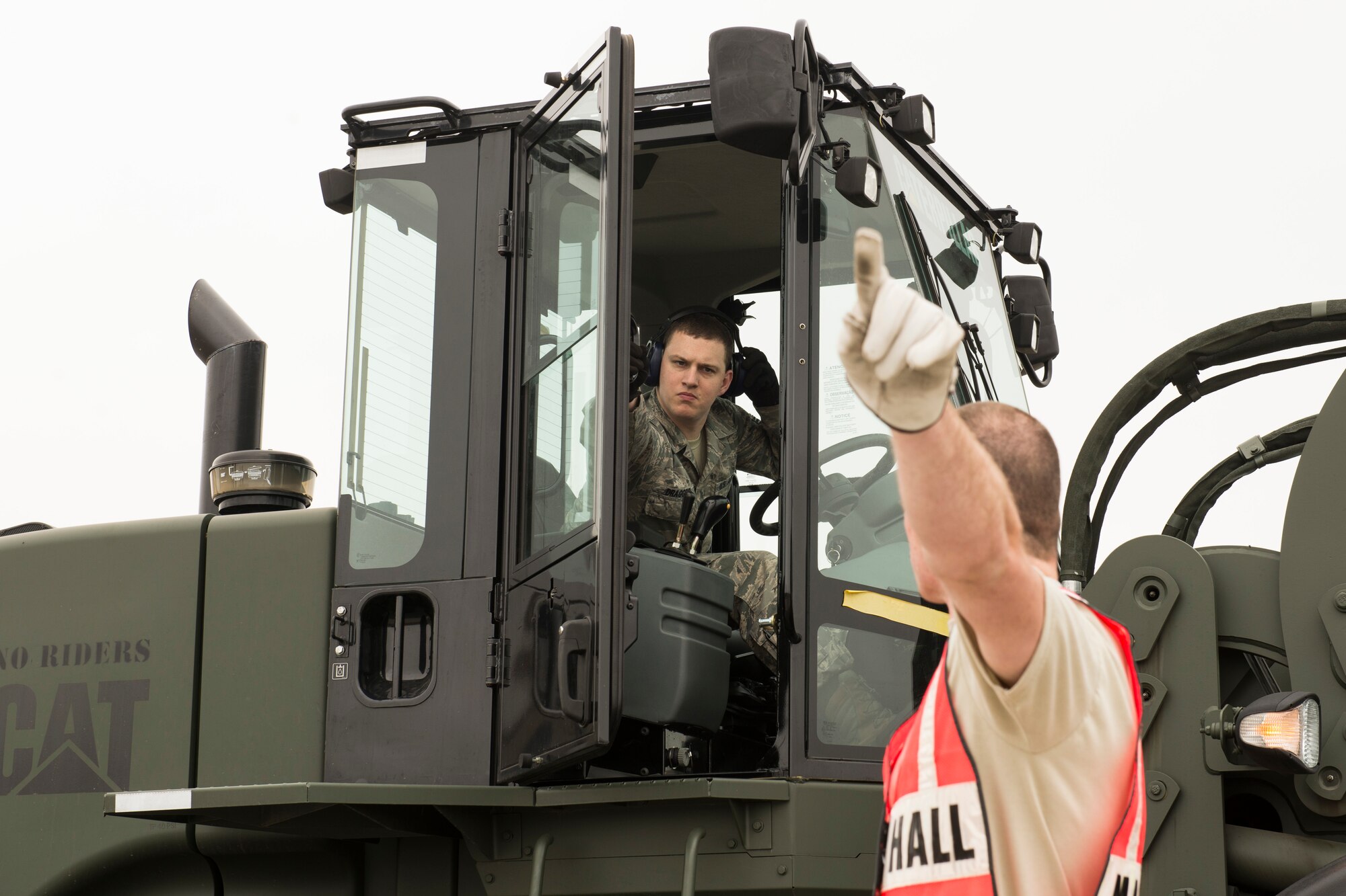 Senior Airman Nathan Draggoo commmunicates cargo movements with Senior Airman Patrick Bollinger during a Samurai Readiness Inspection at Yokota Air Base, Japan, May 13, 2014. The inspection tested the 374th Airlift Wing’s response capabilities to provide humanitarian aid and disaster relief efforts in the Pacific region. Both Airmen were augmentees who assisted the 374 Logistical Readiness Squadron air transportation operations shop throughout the inspection. (U.S. Air Force photo by Staff Sgt. Cody H. Ramirez/Released)