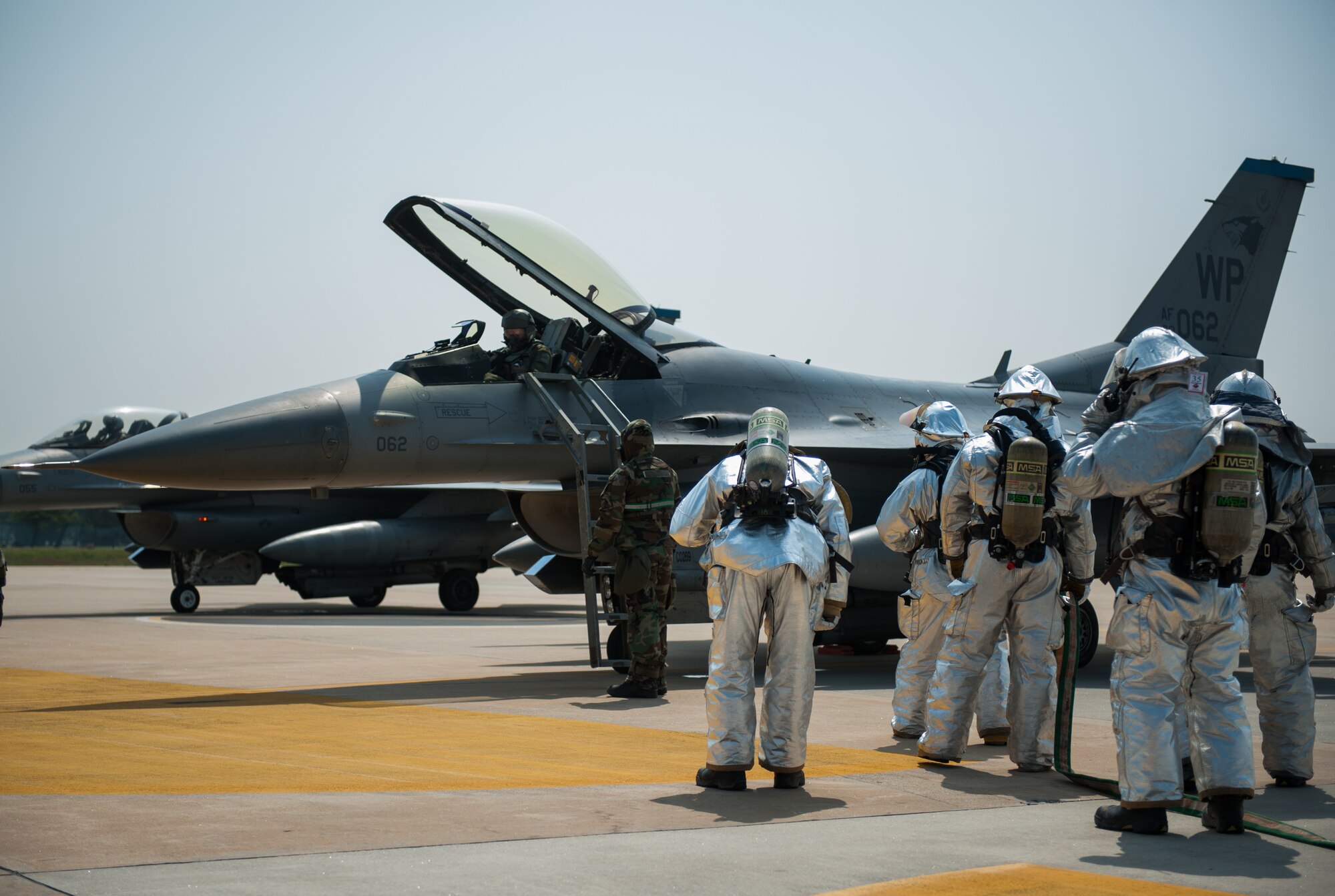 Airmen from the 8th Civil Engineer Squadron fire department respond to a simulated contaminated pilot during exercise Beverly Bulldog 14-2 at Kunsan Air Base, Republic of Korea, May 9, 2014. This exercise tested the Wolf Pack's ability to perform its mission while under threat of chemical attack. (U.S. Air Force photo by Staff Sgt. Clayton Lenhardt/Released)