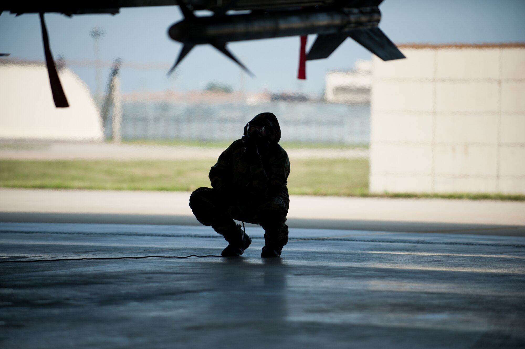 Senior Airman Brendan Walsh, 8th Aircraft Maintenance Squadron crew chief, inspects an F-16 during exercise Beverly Bulldog 14-2 at Kunsan Air Base, Republic of Korea, May 9, 2014. This exercise tested the Wolf Pack's ability to perform its mission while under threat of chemical attack. (U.S. Air Force photo by Staff Sgt. Clayton Lenhardt/Released)