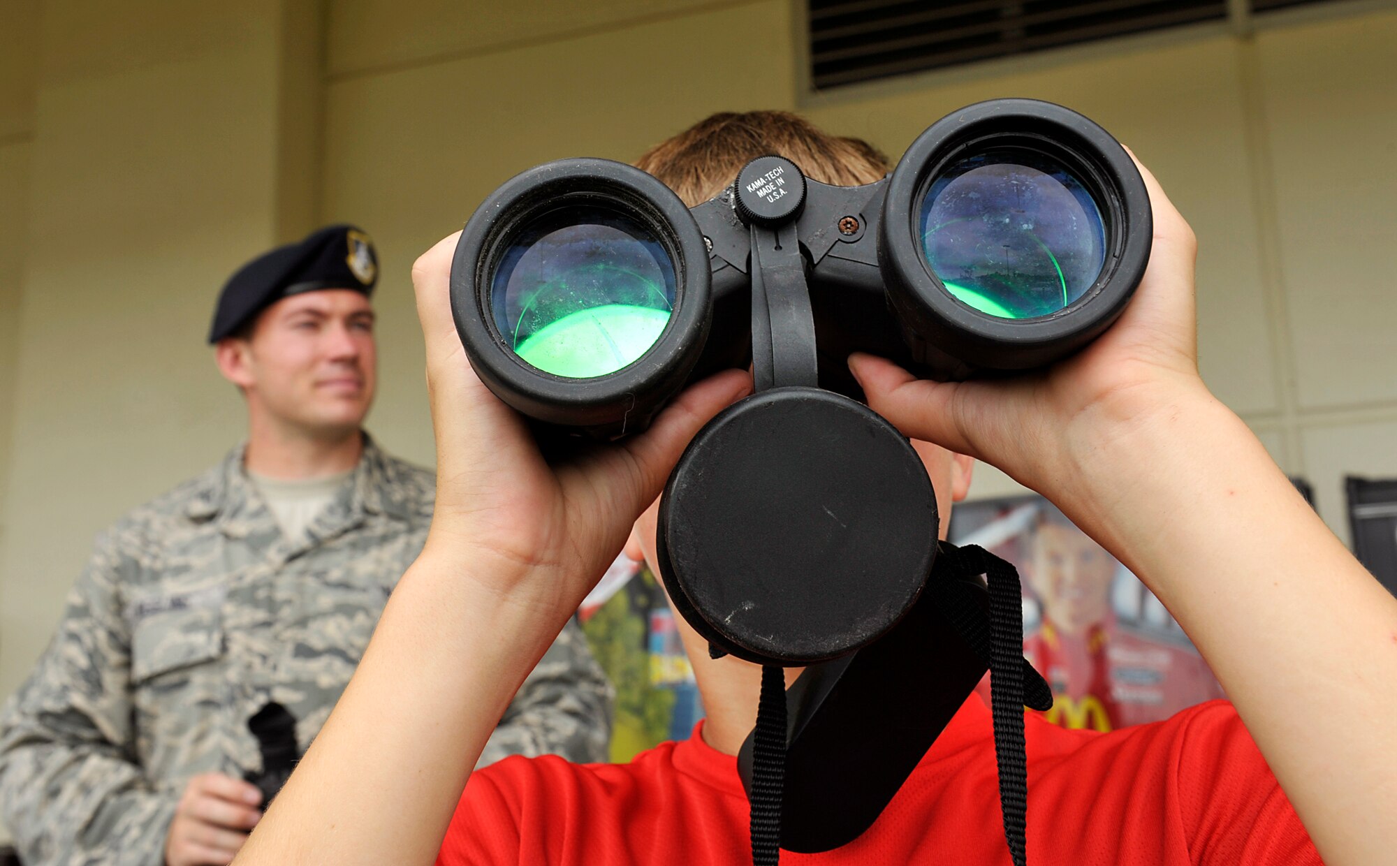 Landon McMinimy looks through binoculars during the Police Week open house on Kadena Air Base, Japan, May 12, 2014. Police Week is a week dedicated to the memory of fallen civilian and military police, and it's a week to show what military police do on a daily basis. (U.S. Air Force photo by Naoto Anazawa)