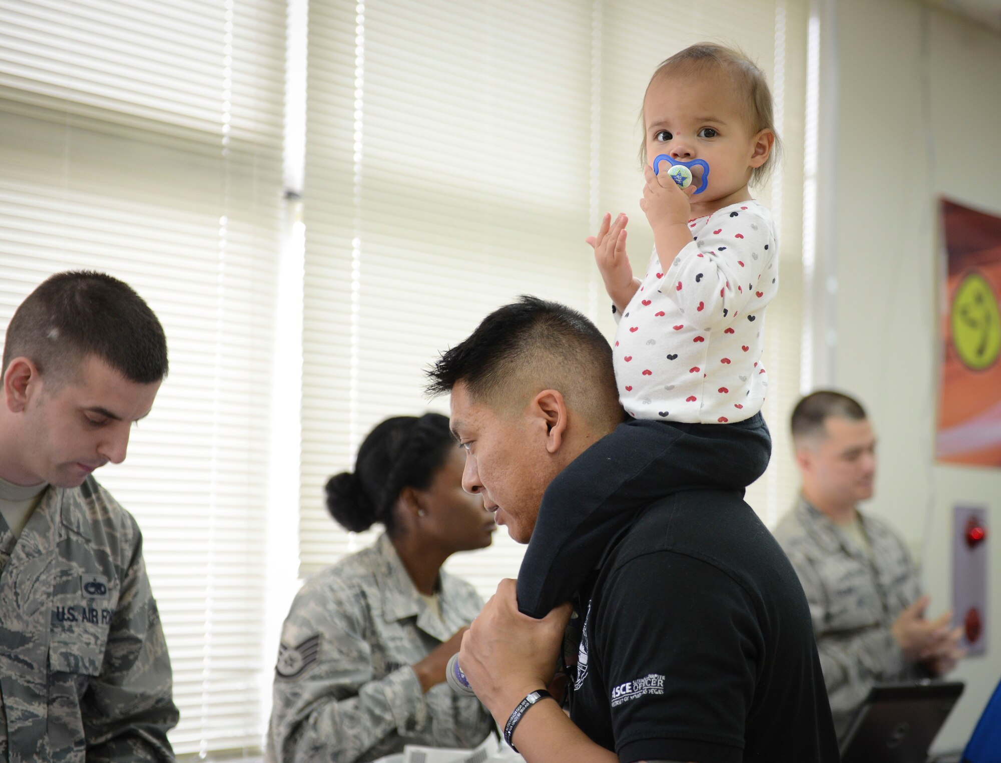 Marco Furlan-Kaneko, 374th Civil Engineer Squadron general engineer, processes through the Taiyo Community Center with his family during a non-combatant evacuation exercise at Yokota Air Base, Japan, May 13, 2014.  The scenario tested the base’s ability to manage a large influx of evacuees and featured several hundred Yokota Airmen and family members. (U.S. Air Force photo by Airman 1st Class Meagan Schutter/Released)