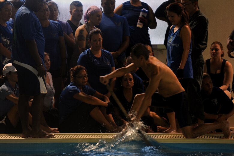 Japan Air Self-Defense Force Warrant Officer Kazuo Ogawa, 83rd Air Wing, Maintenance and Supply Group, Field Maintenance Squadron engine mechanic, demonstrates the proper way to use a paddle on Naha Air Base, Japan, March 26, 2014. Members from the Kadena dragon boat team travelled to Naha Air Base in order to perfect their technique and strengthen their friendship with the JASDF dragon boat team. (U.S. Air Force photo by Airman 1st Class Zade C. Vadnais)