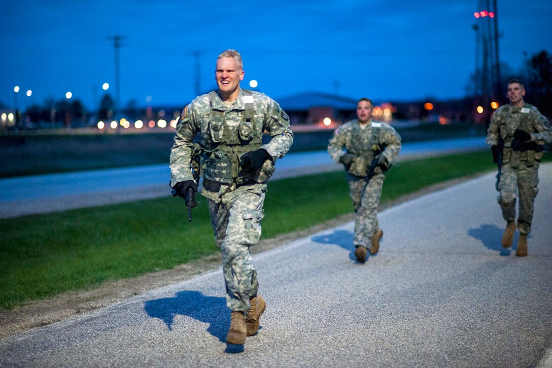 Army Spc. Dalton Hiley, foreground, runs carrying his weapon during the physical fitness portion of Sapper Stakes on Fort McCoy, Wis., May 5, 2014. Hiley is a combat engineer assigned to the 428th Engineer Company.