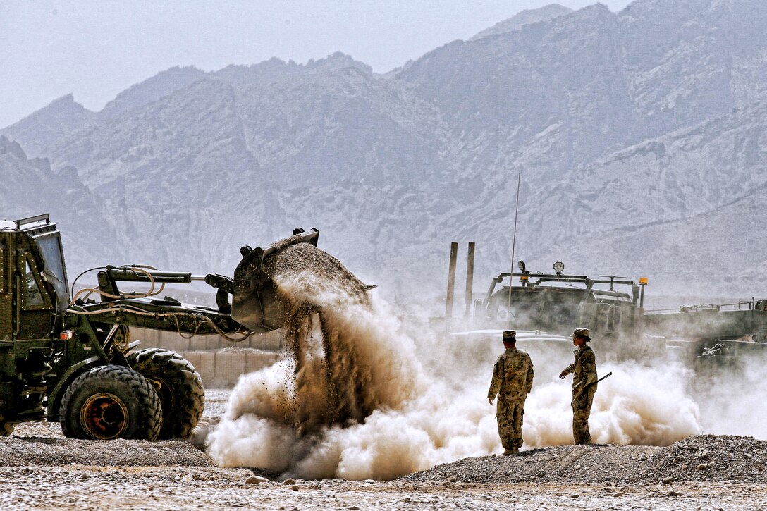 A U.S. soldier operates a bulldozer to fill a hole before closing down Forward Operating Base Hadrian near Deh Rawud village in Uruzgan province, Afghanistan, June 22, 2013. The soldiers are assigned to the 3rd Infantry Division's 2nd Brigade Combat Team.  
