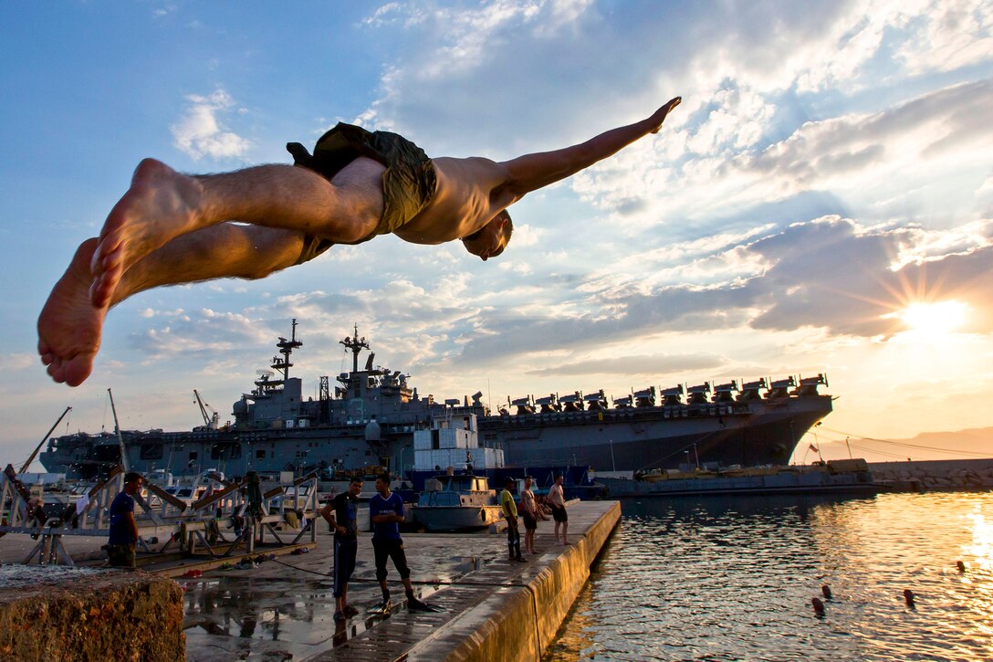 A U.S. Marine dives near the amphibious assault ship USS Kearsarge during a swim call after the conclusion of Exercise Eager Lion 2013 in Aqaba, Jordan, June 22, 2013. The annual, multinational exercise is designed to strengthen military-to-military relationships and enhance security and stability in the region.  
